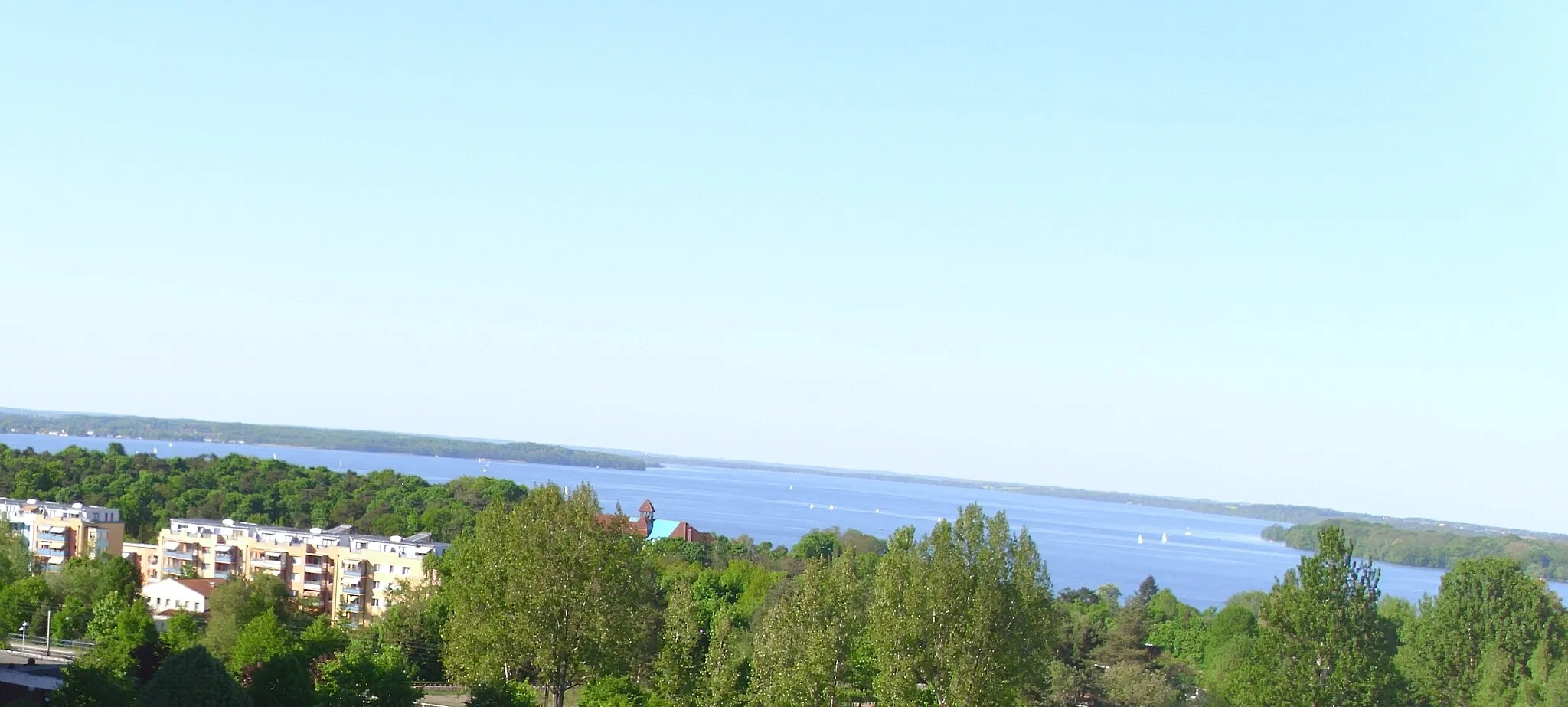 Photo showing: View from district Neu Zippendorf in Schwerin in Mecklenburg-Vorpommern to the Lake Schwerin (German: Schweriner See) with sailing boats. On the left you can see a part of quarter An den Seeterrassen (English: Next to the Lakeside Terraces).