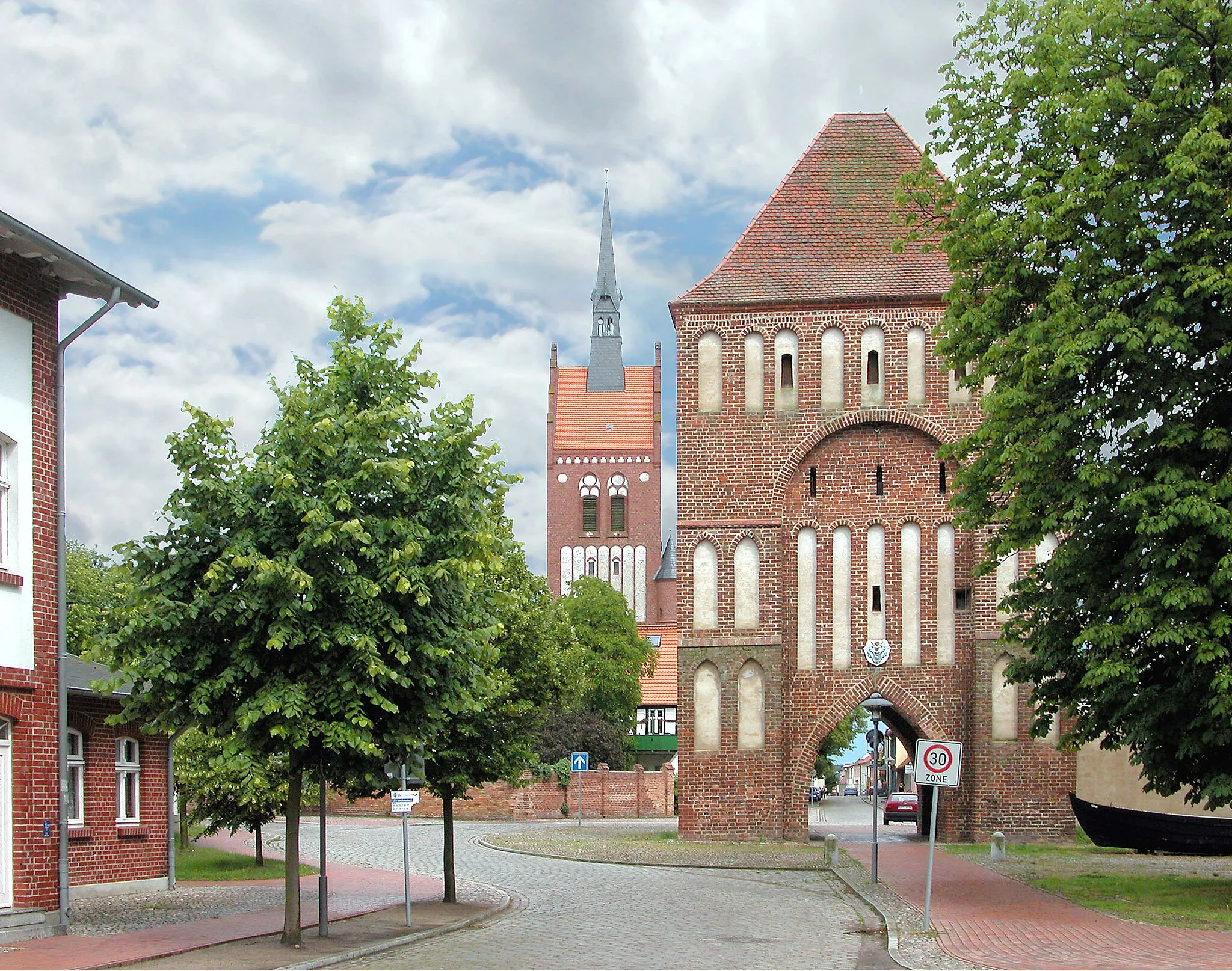 Photo showing: 01.07.2004   17406  Usedom, Anklamer Straße: Anklamer Tor (GMP: 53.872468,13.918043), spätgotisch um 1540. Dahinter die  Stadtkirche St. Marien (GMP: 53.872543,13.919715). Sie wurde erstmals 1337 erwähnt, 1475 bei Stadtbrand zerstört. Sehr solide war der Bau nicht. Turm und Altarraum erhielten in den Jahren 1891 bis 1893 bei einer notwendig gewordenen Restaurierung ihre heutige Gestalt. Nach einem Entwurf von Ludwig Böttger wurde die Kirche auf dem ursprünglichen Grundriss weitgehend neu errichtet. Dabei wurde der Turm wurde neogotisch überformt.                [DSCN4618.JPG]20040701300DR.JPG(c)Blobelt