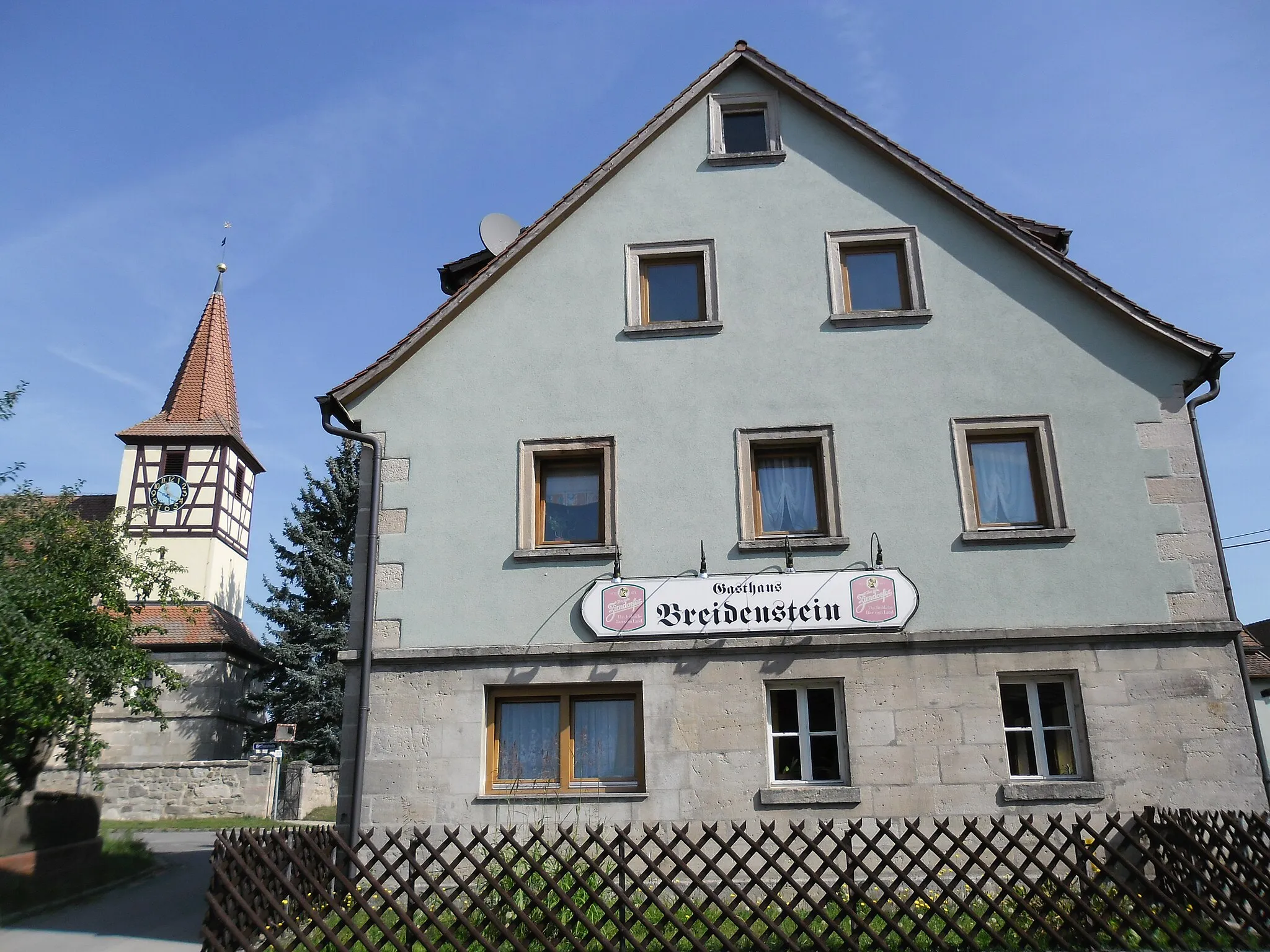 Photo showing: Die evangelische Filialkirche St. Bartholomäus stammt aus dem 15. Jahrhundert, auf einem Sandsteinbau thront ein Fachwerkchortürmchen.