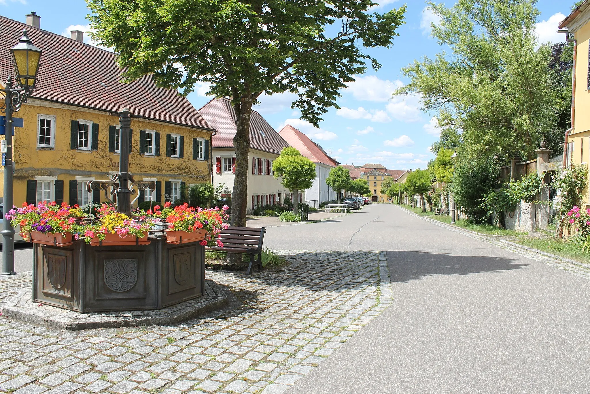 Photo showing: Marktplatzbrunnen und Schlossstraße mit Hofgartenmauer in Bartenstein, im Hintergrund das Fürstenschloss