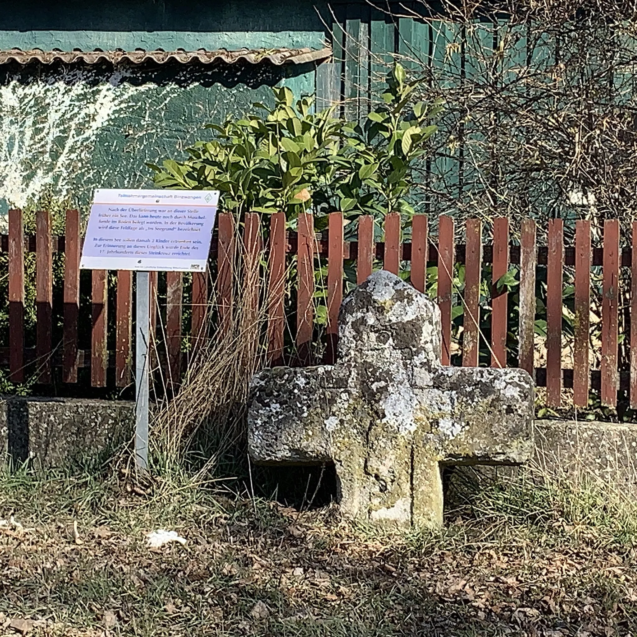 Photo showing: Steinkreuz in Poppenbach im Gemeindegebiet Colmberg mit einem Hinweisschild, das die Hintergründe schildert. Es wird vermutet, dass am Standort des Steinkreuzes früher ein kleiner See war, in dem zwei Kinder ertranken. Das Steinkreuz sei als Erinnerung an diese Kinder errichtet worden.