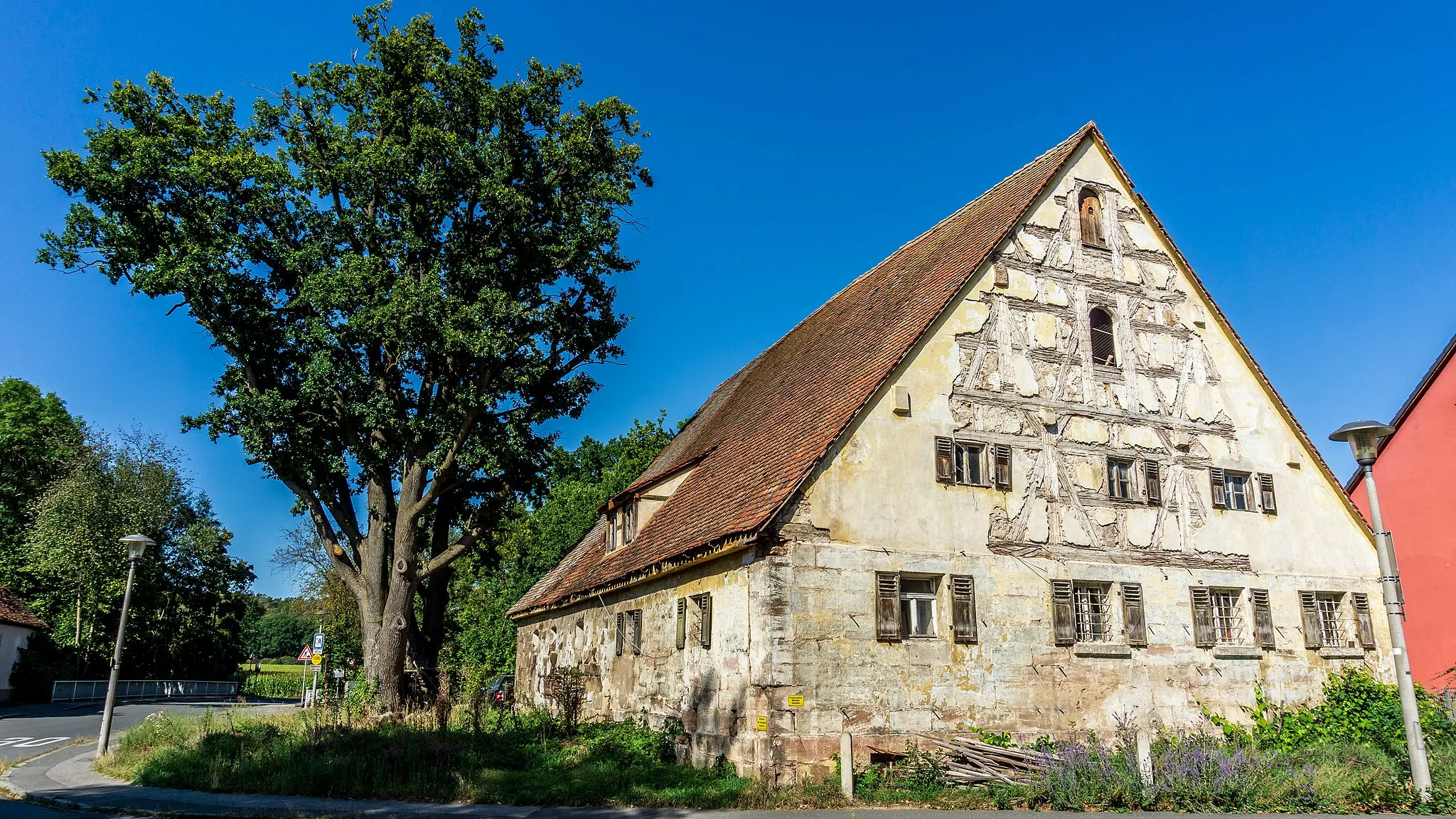 Photo showing: Eingeschossiger freistehender Satteldachbau mit Giebel- und Schleppgauben, verputzter Sandsteinquaderbau mit verputzten Fachwerkgiebeln, 18./19. Jahrhundert