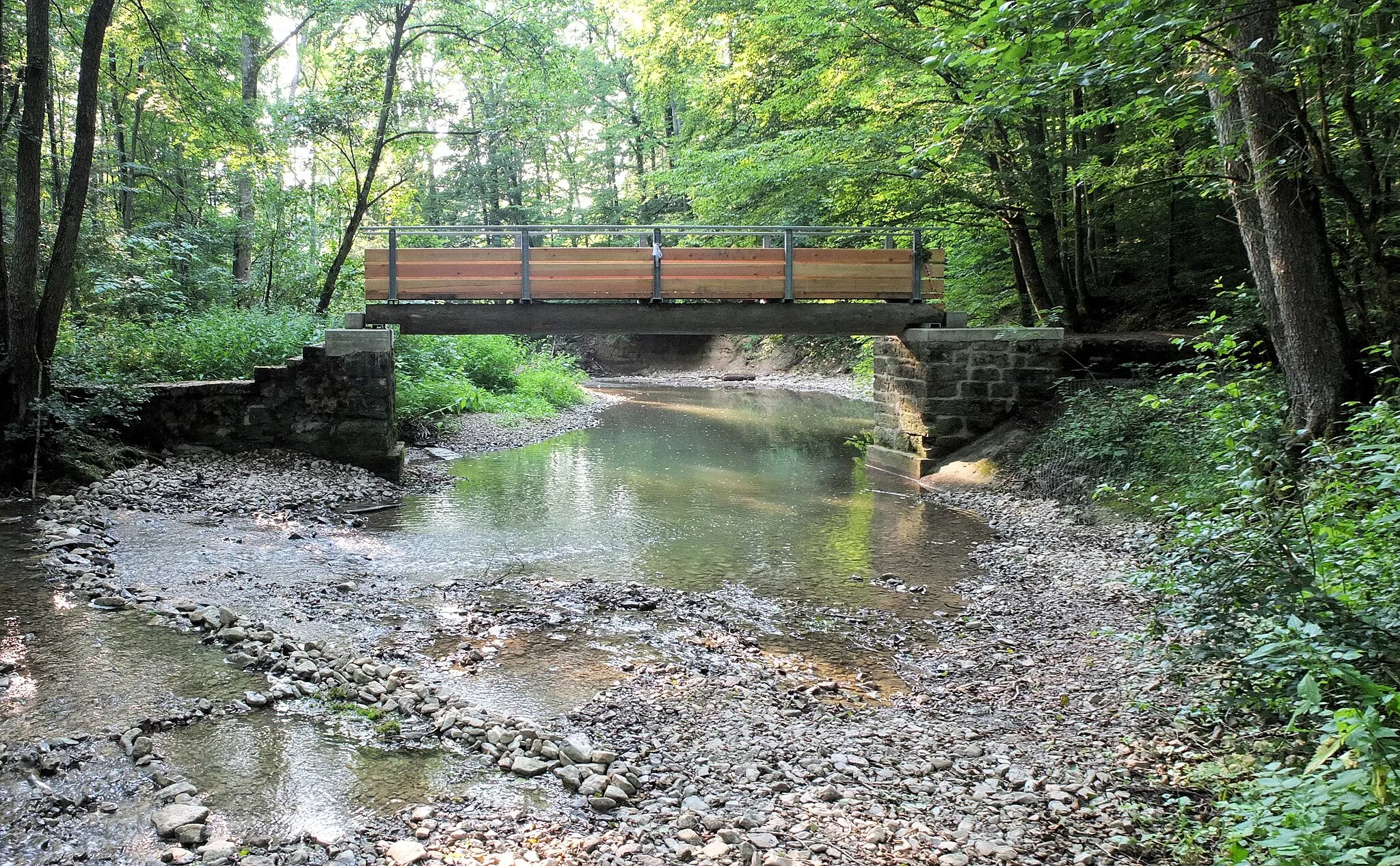 Photo showing: Der Schwarze Steg im Kupfertal nahe Forchtenberg. Diese Brücke über die Kupfer wurde anstelle einer alten Brücke ähnlicher Bauart 2012 neu erbaut. Über sie verläuft der Georg-Fahrbach-Weg.