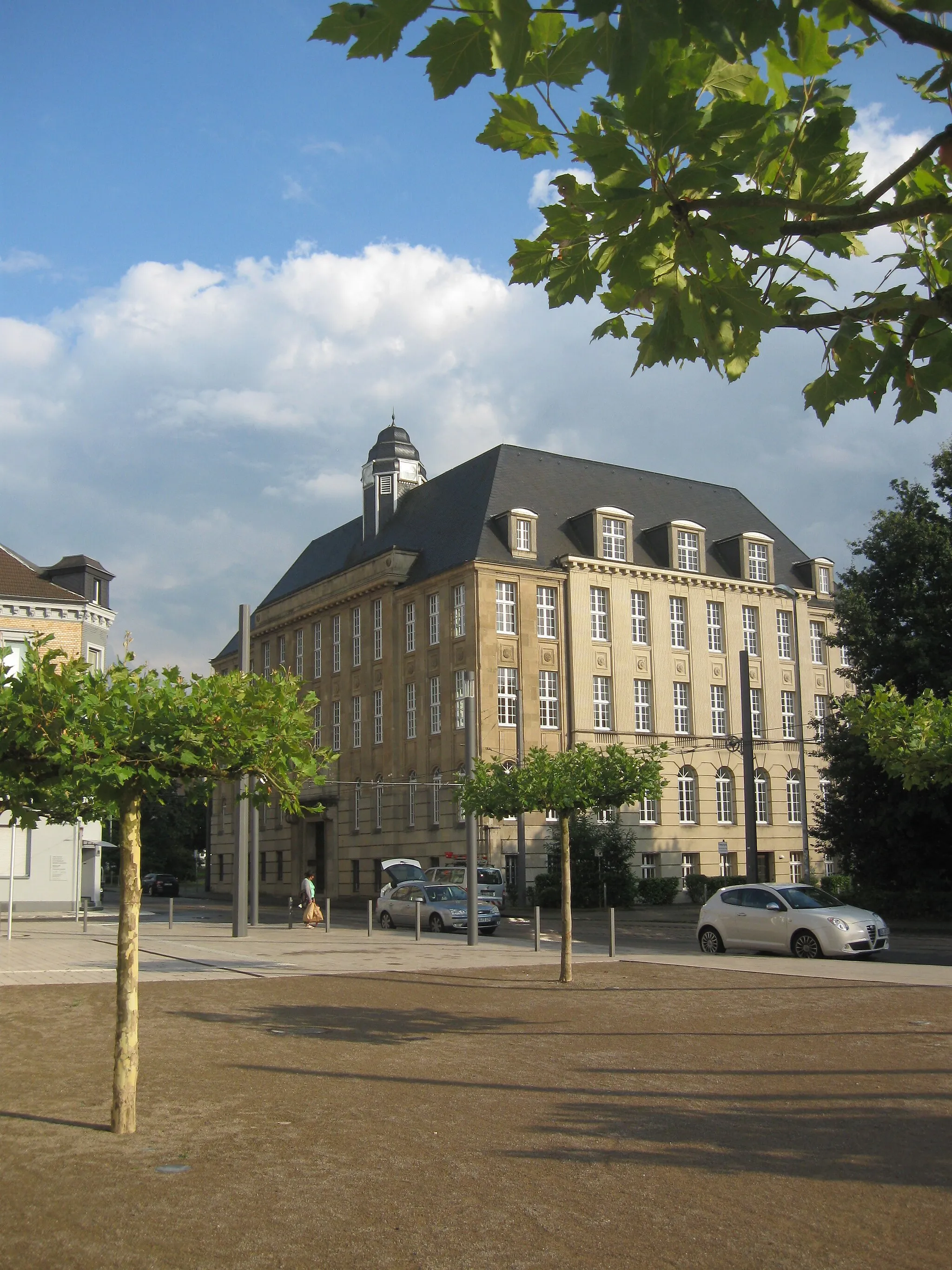 Photo showing: Blick über den Vorplatz des neuen Justizzentrums Gelsenkirchen auf das gegenüberliegende Gebäude Bochumer Straße 86 (eh. Verwaltungsgebäude der Thyssen-Gießerei, in dem 1993–2016 das Arbeitsgericht Gelsenkirchen untergebracht war).