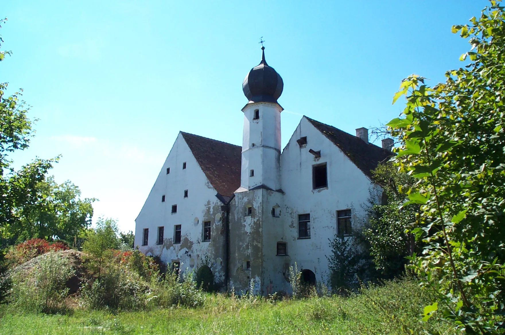 Photo showing: Laberweinting, Grafentraubach Hausnummer 201. Das Wasserschloss ist eine bescheidene und doch originelle Anlage aus dem 16. Jahrhundert. Zwei parallel gestellte, zweigeschossige, unregelmäßige Giebelbauten, von denen der südliche etwas höher ist. An der Hofseite des kleineren Baues, nahe der Mitte der Gesamtanlage erhebt sich ein Turm mit ungegliedertem Unterbau, indem sich das Treppenhaus befindet. Das achteckige Obergeschoss ist mit einer barocken, gekröpften Kuppel mit Kreuz gedeckt. Im Erdgeschoss befinden sich gewölbte Wirtschaftsräume. Unter dem rechten Giebel befindet sich ein Aufzug, der innen mit einer hölzernen Winde mit Muskelkraft bedient werden konnte.