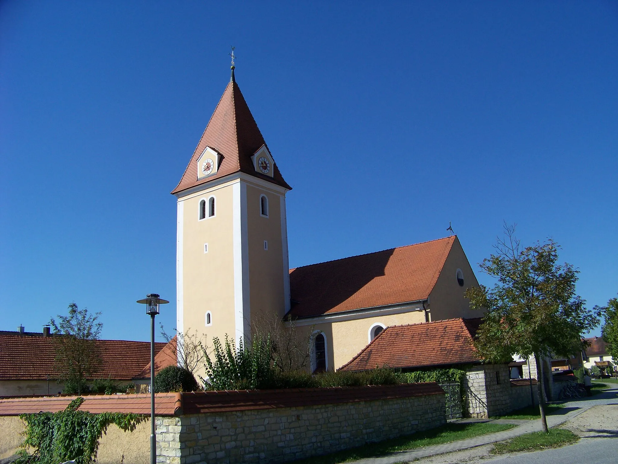 Photo showing: Hausen, Großmuß, Kirchstraße 4. Katholische Kirche St. Georg. Saalkirche mit Satteldach und eingezogenem, aus der Achse verschobenen Kastenchor, 1937, ehem. Chorturm, mit Uhrengiebeln und Pyramidendach, 1. Hälfte 14. Jahrhundert, Erweiterung im 18. und 19. Jahrhundert; mit Ausstattung; Seelenkapelle, Walmdachbau aus Natursteinmauerwerk mit Bossierung, 1937; Friedhofsmauer, Natursteinmauerwerk mit Bossierung und Ziegelabdeckung.