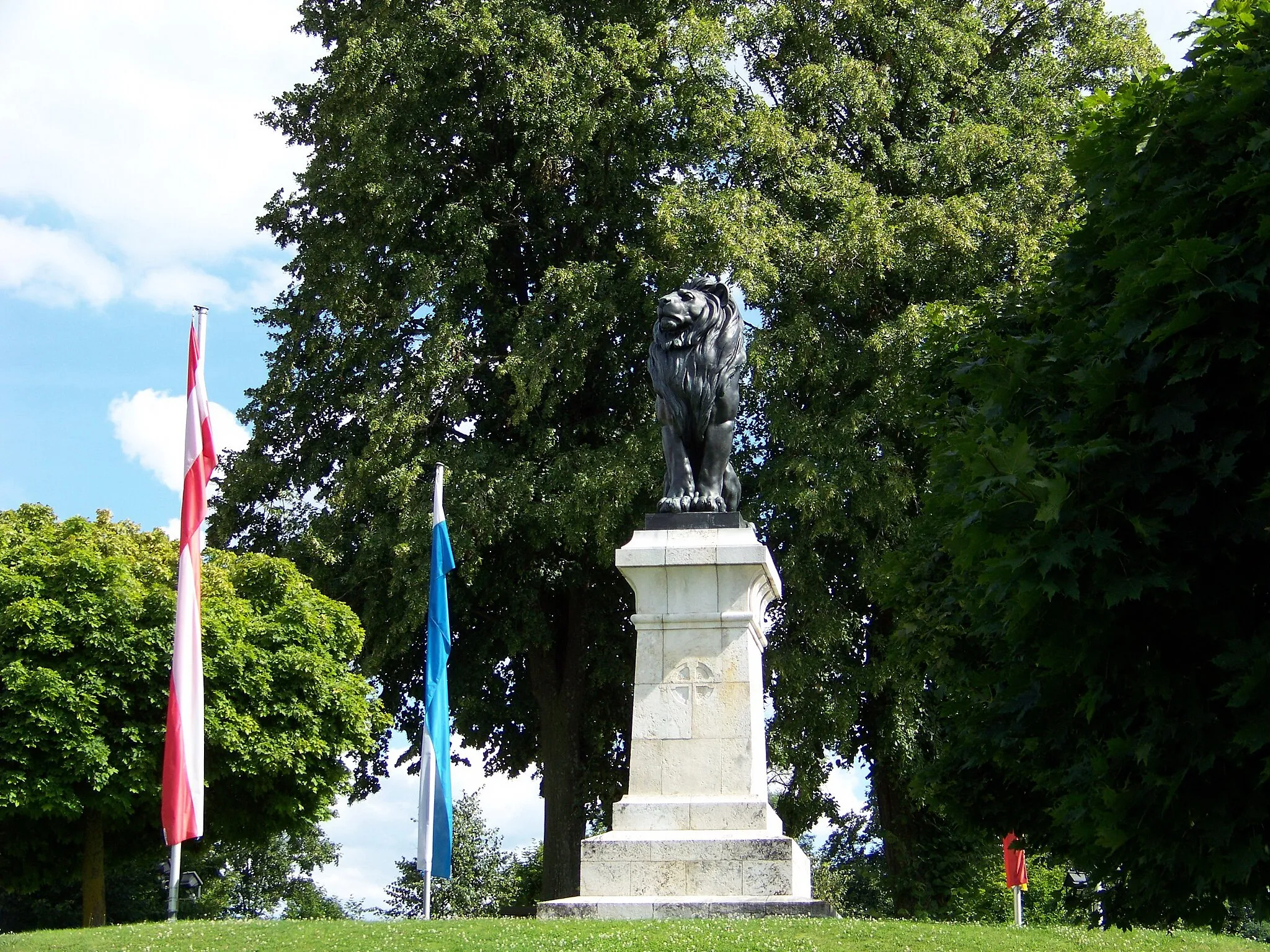 Photo showing: Am Löwendenkmal. Löwendenkmal um Andenken an die Schlacht vom 22. 4. 1809,
auf Hügel stehender Pfeiler mit gestuftem Unterbau, sitzendem Löwen Inschriften und Wappen, Kalkstein und Bronze, Entwurf Ferdinand von Miller, 1909.