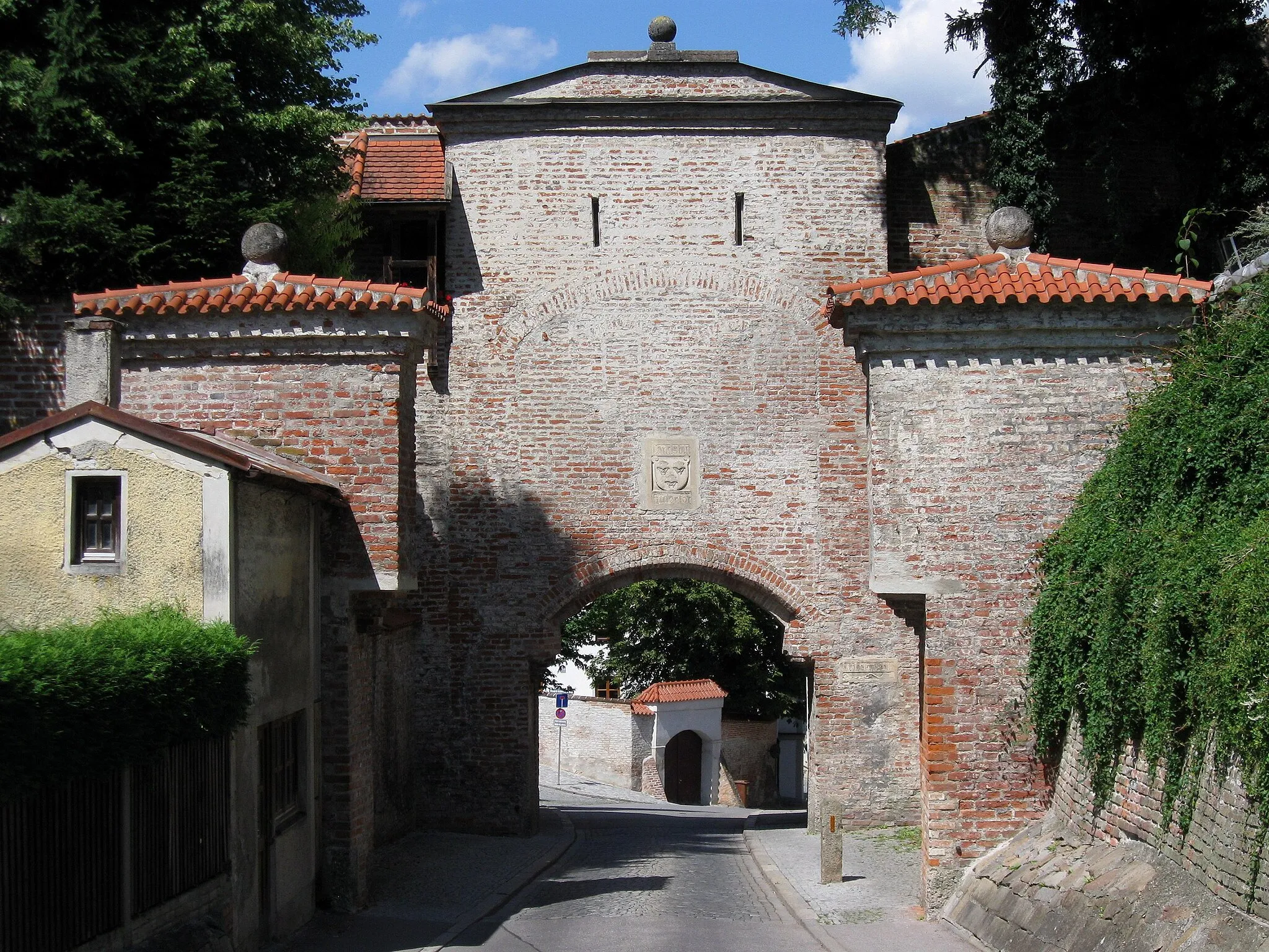 Photo showing: Alte Bergstraße; Burghauser Tor (Huetertor), spätgotische Toranlage der mittelalterlichen Stadtbefestigung, unverputzter Ziegelbau mit Wappen, 1. Hälfte des 14. Jh., um 1800 klassizistisch umgestaltet.