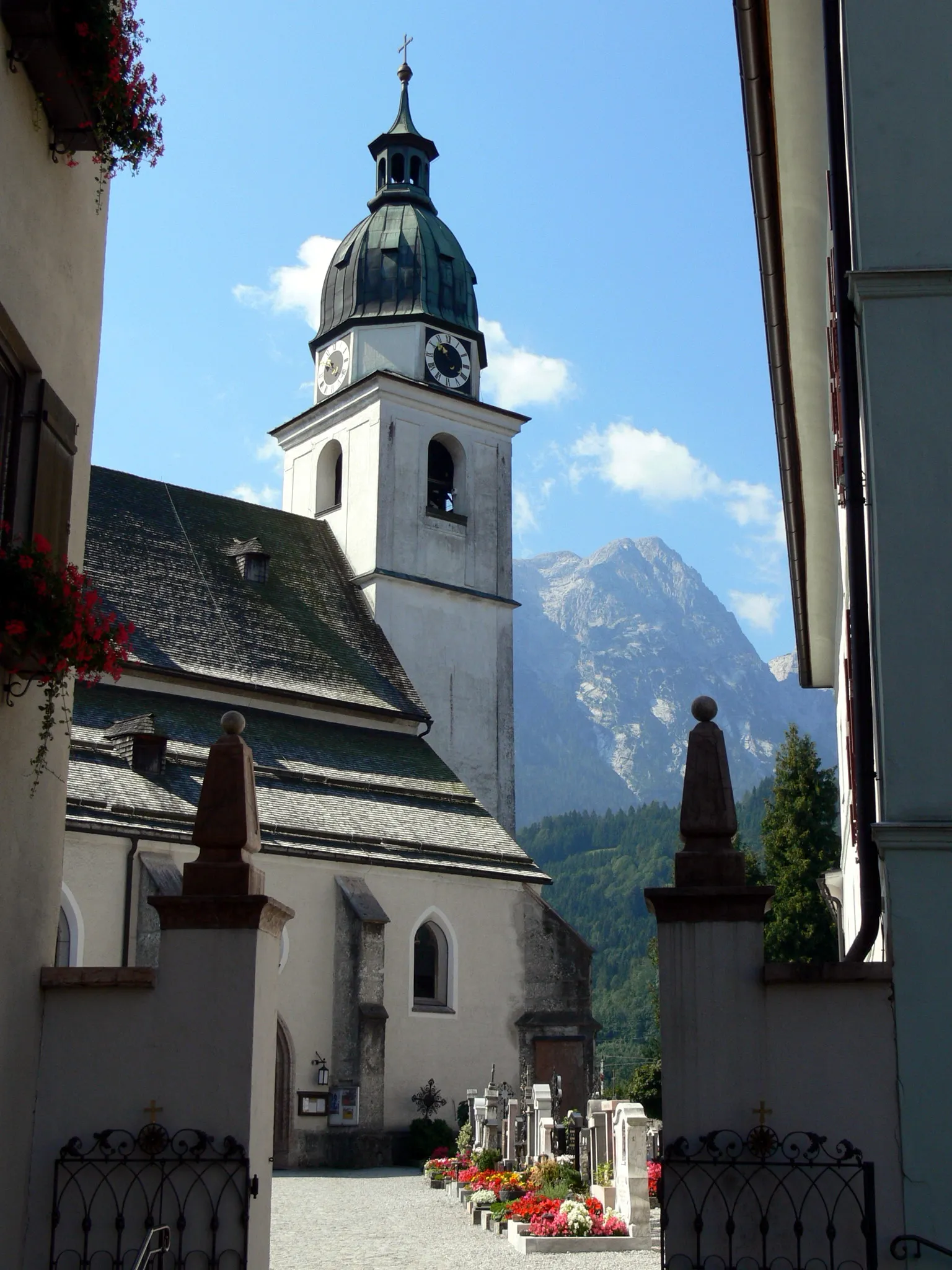 Photo showing: Kuchl parish church ( Salzburg ). Tower of the church. In the background: Hinteres Freieck 2309 m