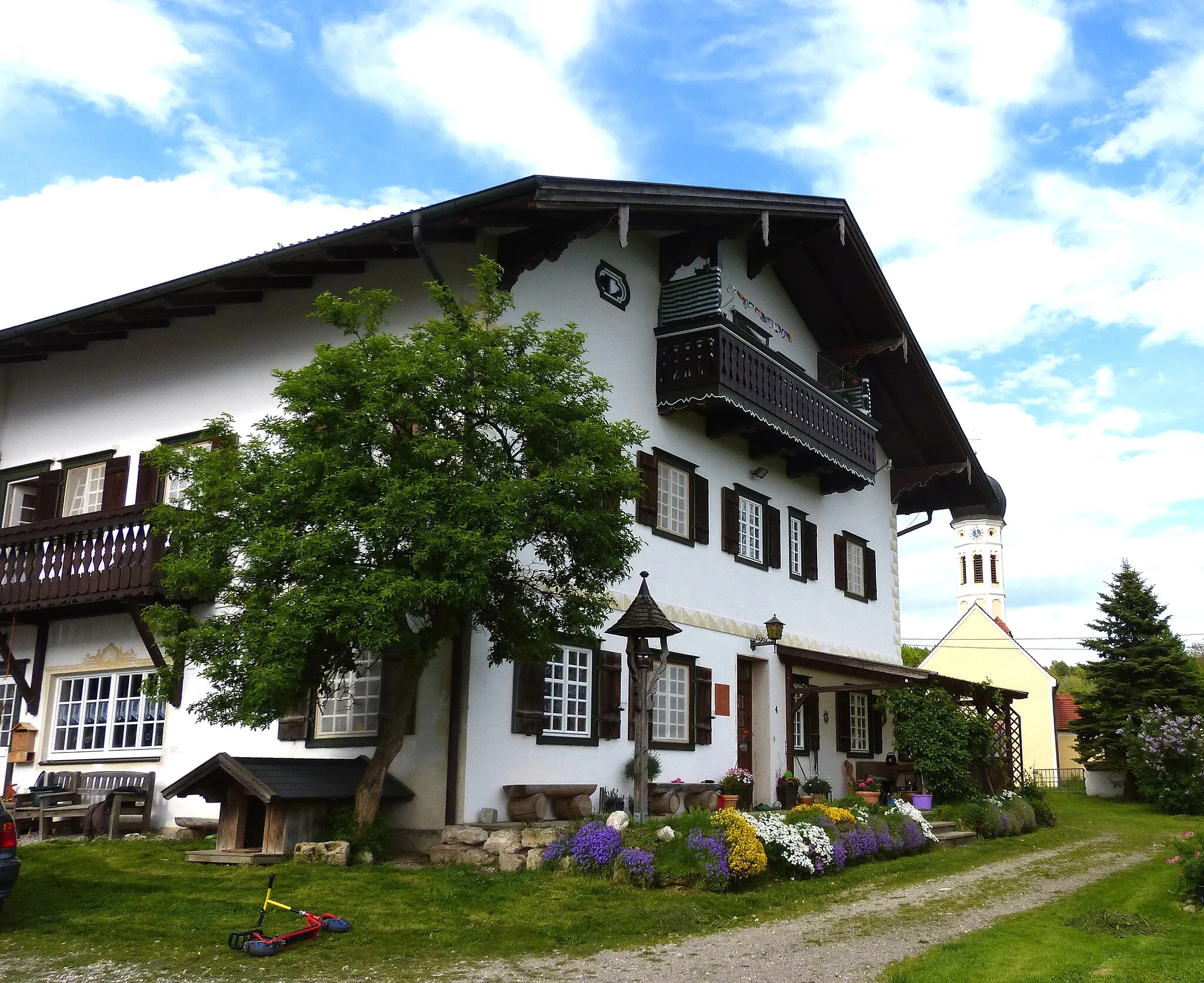 Photo showing: Tutzing, OT Monatshausen, Monatshausen 4. Das Gutshaus, ein zweigeschossiger Satteldachbau nach Art eines Miesbacher Einfirsthofes, wurde 1908 von August Thiersch für Theodor Freiherr von Cramer-Klett erbaut.