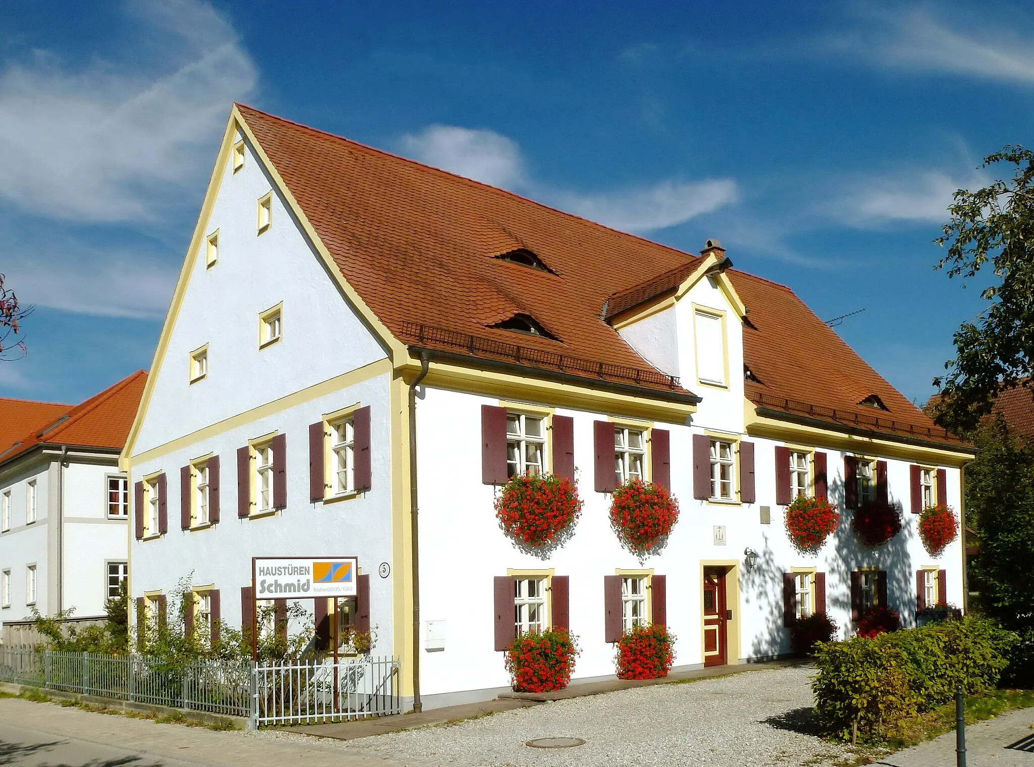 Photo showing: Sulzemoos, Kirchstr.5: Ehemaliges Pfarrhaus mit Dachauer Haustafel (mittig oberhalb der Eingangstür) und kleiner Sonnenuhr (rechts oberhalb der Eingangstür), Ansicht aus SW