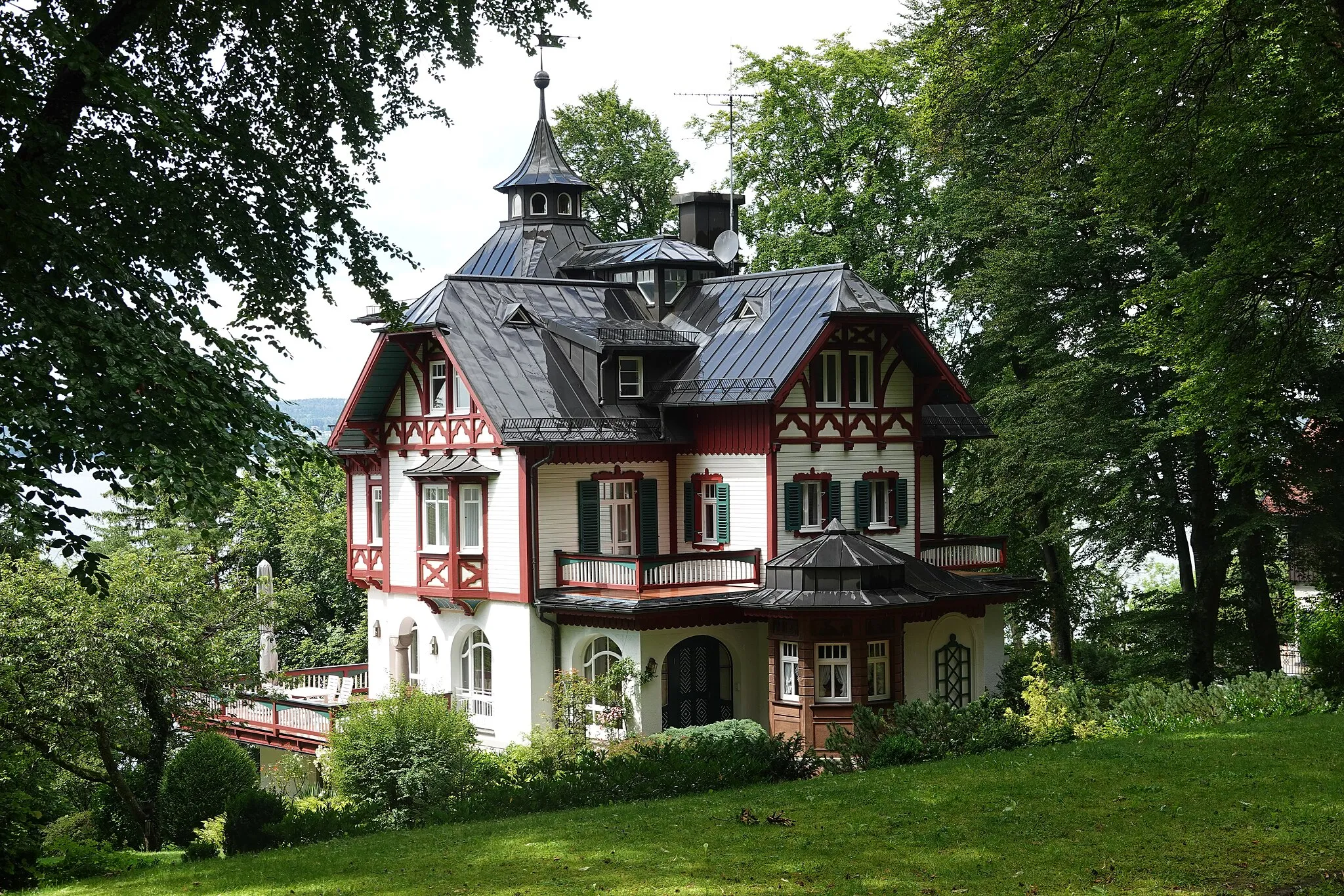 Photo showing: Zweigeschossiger teilweise verschalter Gruppenbau in Heimatstilformen über Sockelgeschoss mit Schopfwalmdächern, reichem Zierfachwerk, Turm und Erkern, 1902.