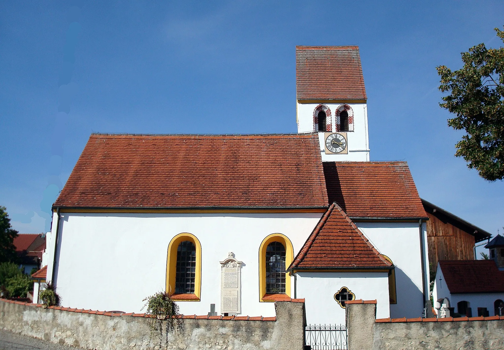 Photo showing: Pöcking, Ortsteil Aschering, St.-Sebastian-Straße 18. Kirche St. Sebastian. Erste Hinweise auf eine Kirche in Aschering stammen aus dem Jahre 1263. Die gotischen Spitzbogenfenster an drei Seiten des Turmes lassen darauf schließen, dass die heutige Kirche im ausgehenden 15. Jahrhundert erbaut wurde. Eine Inschrift auf der ältesten Kirchenglocke datiert ihren Guss auf das Jahr 1519. Der Innenraum der Kirche erhielt 1768 bei einer umfasssenden Renovierung seine spätbarocke Gestaltung.[1]