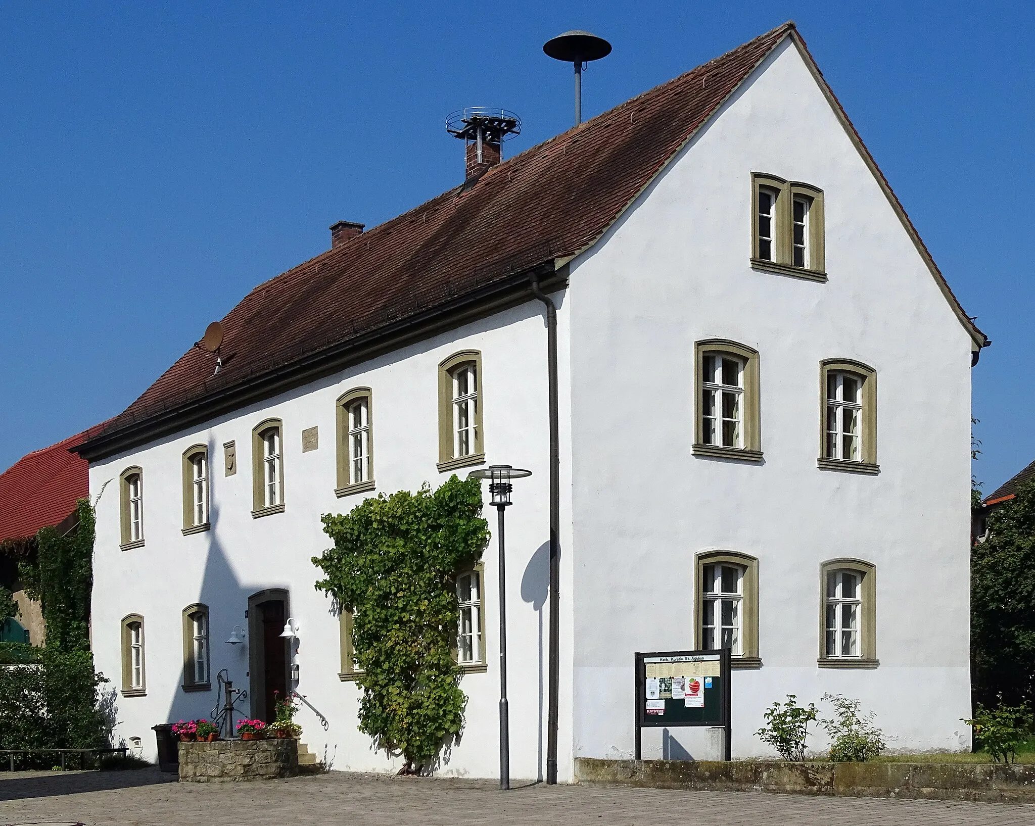 Photo showing: Former school in Mönchherrnsdorf, Zum Zehnthof 6. The red building left represents the former chapel. Both buildings are built together