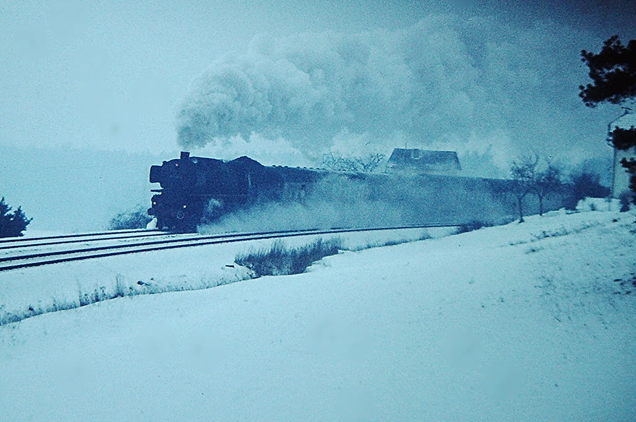 Photo showing: DB Class "001" (DRG Class "01") coal-fired 4-6-2 No.001 150 in largely original condition with small boiler, narrow chimney but without front fall plate, 02/73. 001 150 is climbing the Schiefe Ebene on a Bamberg - Hof express. Scanned slide taken with a Kowa SET.