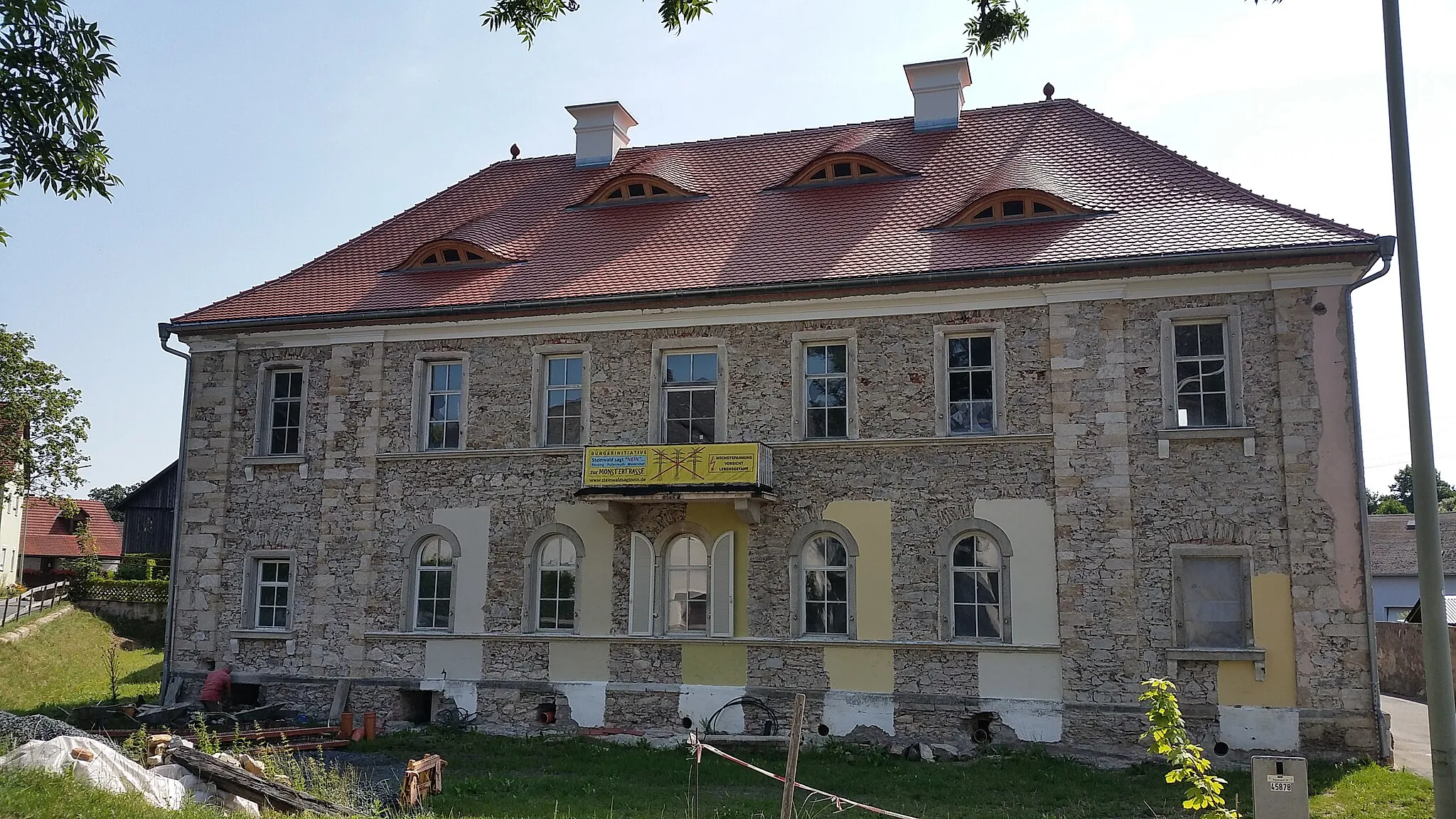 Photo showing: Ansicht Westseite des momentan unverputzten Hauptgebäudes mit Farbmuster für künftigen Fassadenanstrich.