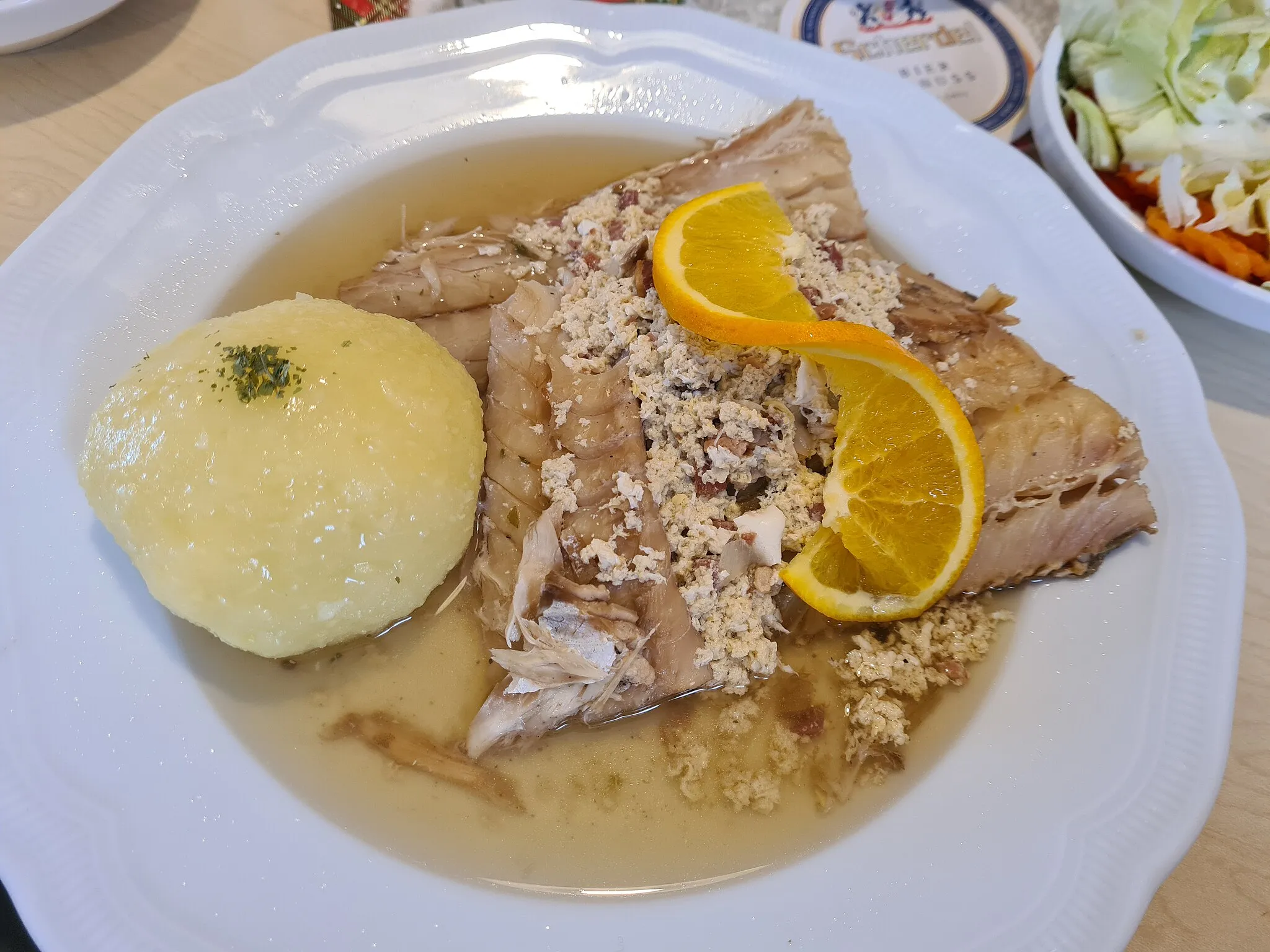 Photo showing: Stockfish with egg broth and potato dumpling. As a side dish there was a mixed salad. Photographed at the Gasthaus zur Elsa in Epplas.