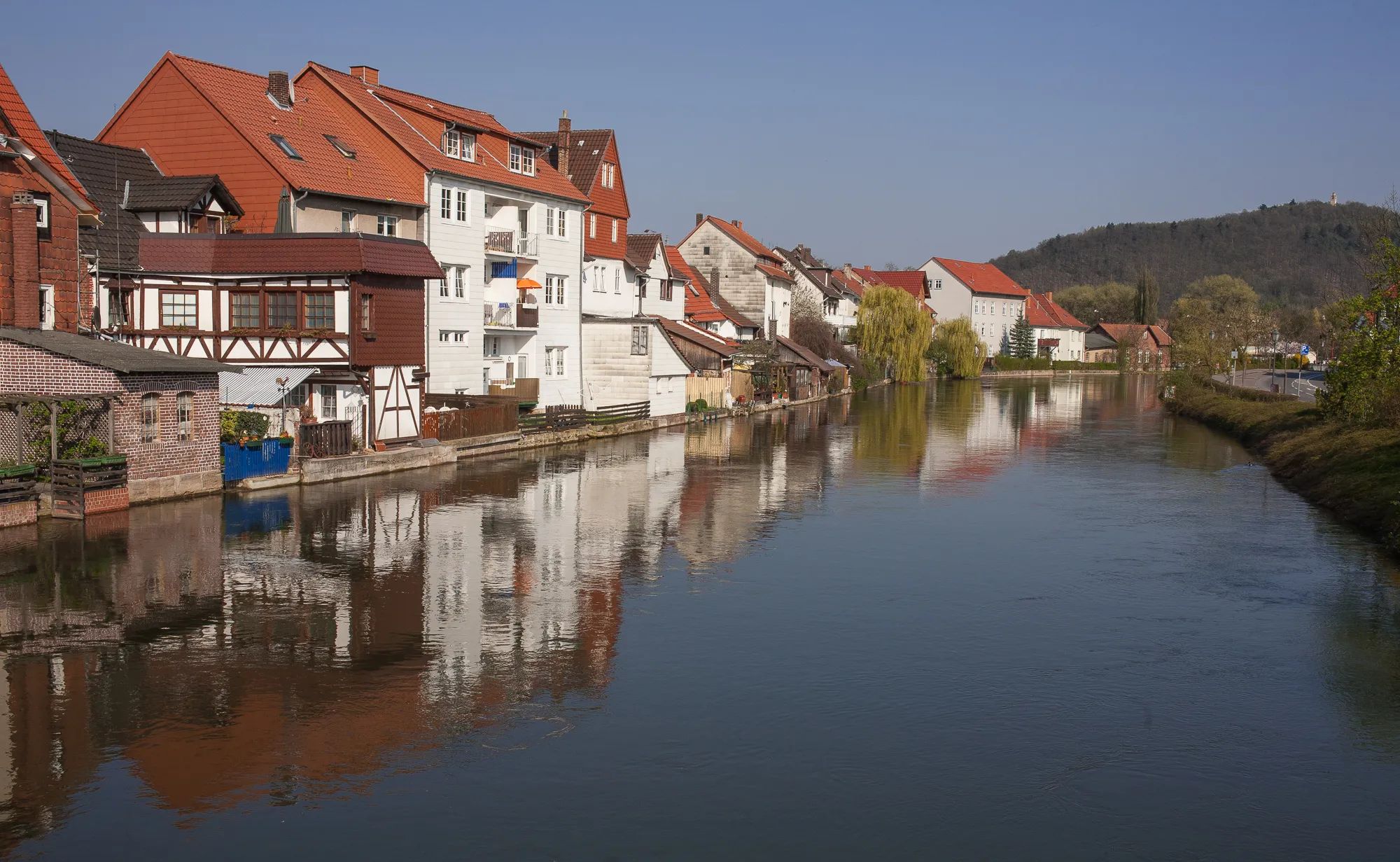 Photo showing: Buildings on the river Werra in Eschwege. View from the bridge over the main branch of the river Werra in Eschwege. In the background the tower "Bismarckturm" on the mountain "Leuchtberg".
