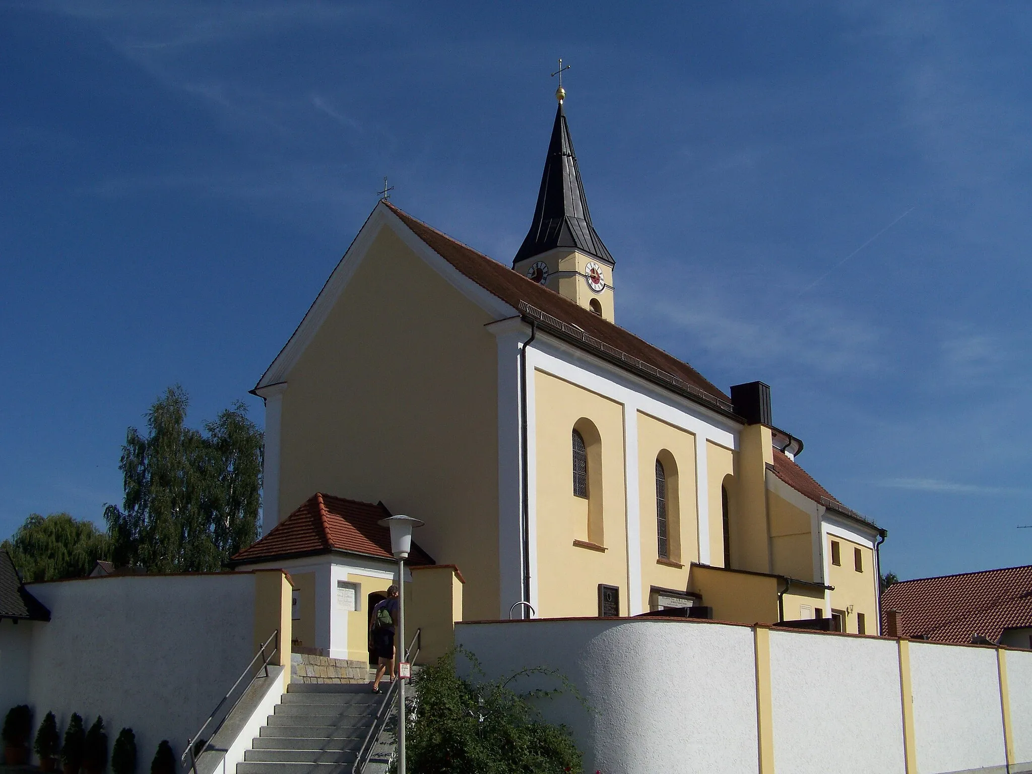 Photo showing: Leiblfing, Hankofen, Sankt-Georg-Ring 3. Katholische Filialkirche St. Georg. Einheitlicher Bau um 1799. Kirche des Kuratbenefiziums St. Georg. Sie wurde unter dem Benefiziaten Buechberger auf der Grundlage der 1749 vorgelegten Pläne des Straubinger Stadtmaurermeisters Caspar Haagn erbaut. Turm an der Südseite des Chores mit hohem Untergeschoß. Sakristei südlich am Chor. Der Eingang führt durch das westliche Vorzeichen.