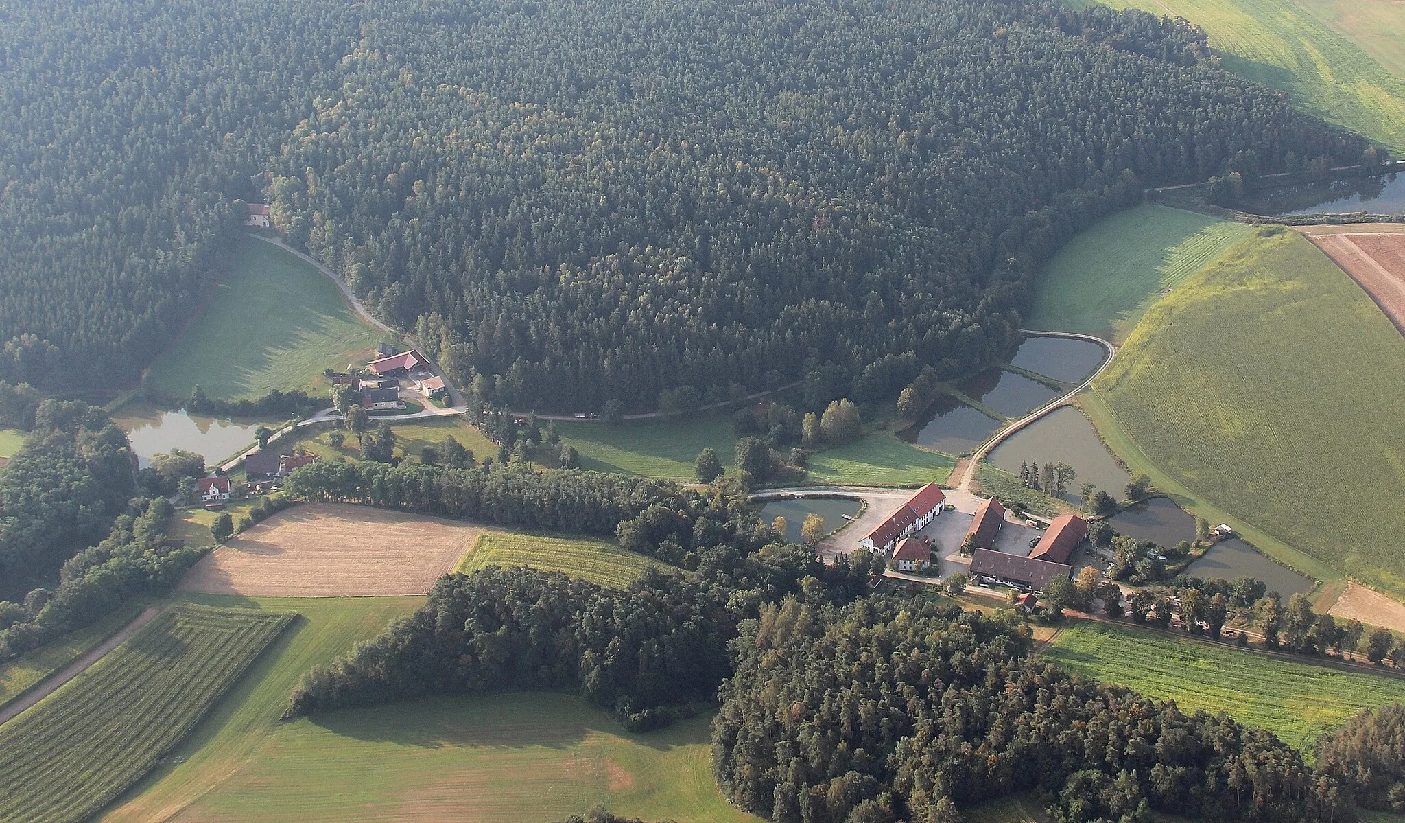Photo showing: Büchlhof (Bildmitte rechts), Kemnathermühle Bildmitte links unten), Neuhäusl (Bildmitte links oben) und Kirche Büchlberg (im Wald); Stadt Neunburg vorm Wald, Landkreis Schwandorf, Oberpfalz, Bayern
