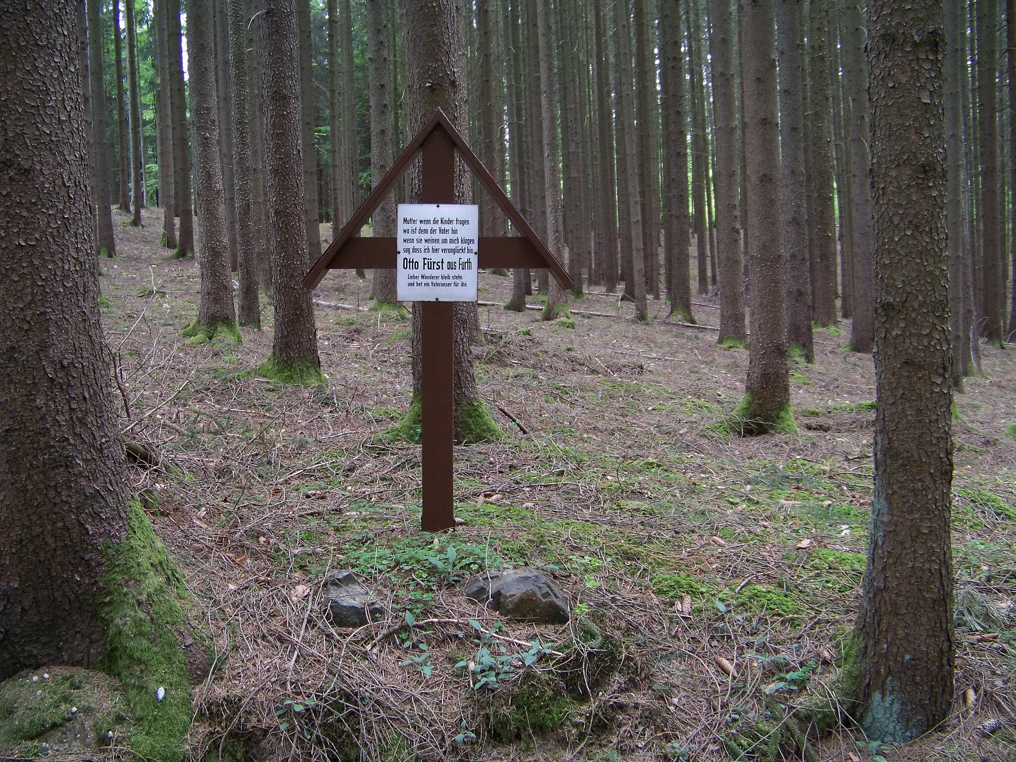 Photo showing: Am Kiesweg beim alten Nußberg zwischen Neuhofen und Pramersbuch findet man nach etwa 550 Metern das Fürst Marterl. Der Familienvater Otto Fürst aus Furth hatte hier am 9. Januar 1959 einen tödlichen Unfall mit einem Bulldog-Gespann.
Es handelt sich um ein überdachtes Holzkreuz.
Statt eines Kruzifix ist eine Tafel mit einem sehr emotionalen Text angebracht.
Mutter wenn die Kinder fragen
wo ist denn der Vater hin
wenn sie weinen, um mich klagen,
sag, dass ich hier verunglückt bin.
Otto Fürst aus Furth
Lieber Wanderer bleib stehn
und bet ein Vaterunser für ihn.
Die heutige Verbindungsstraße SR53 - DGF 42 wurde erst Mitte der 1960er Jahre gebaut. Bis dahin führte die einzige Verbindung von Pramersbuch in nördliche Richtung über den Kiesweg am sogenannten Nußberg. Dieser Kiesweg war sogar eine Kreisstraße des Landkreises Mallersdorf. Der Unfallhergang wird von der Familie wiefolgt beschrieben: Am 9. Januar 1959 fuhr der Landwirt Otto Fürst alleine mit Bulldog und Anhänger Weizensäcke zur Mühle nach Geiselhöring zum Mahlen. An dem Tag war es spiegelglatt.

Vermutungen zum Unfallhergang: An der steilsten Stelle am Nußberg wollte er bremsen. Durch den Schub des Anhängers hat sich der Bulldog quer gestellt und kippte um. Otto wurde zwischen Schutzblech und Sitz eingeklemmt und erstickte an den Quetschungen.