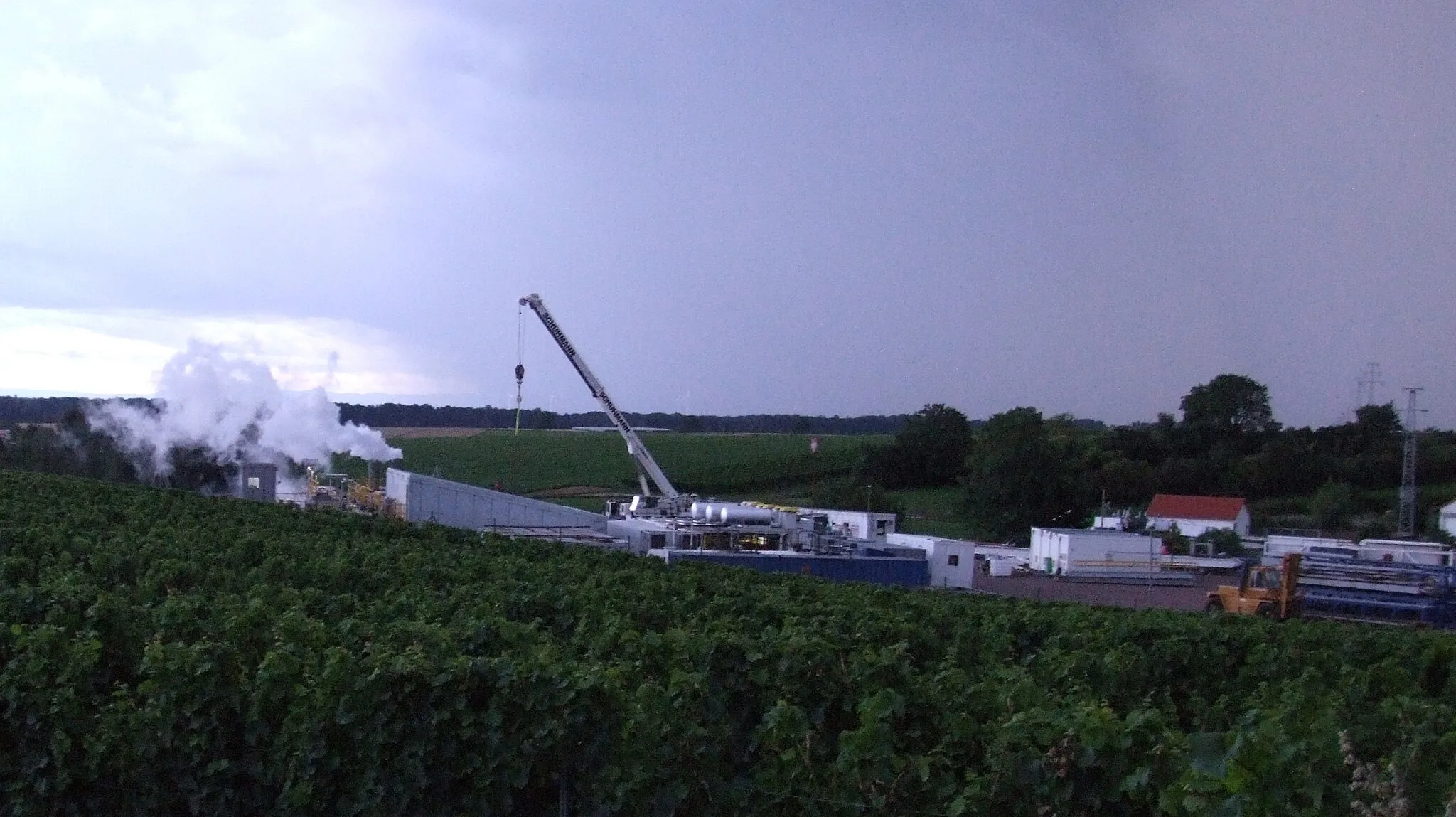 Photo showing: Geothermiebohrung Insheim am 23.7.2009 in den Weinbergen. Aus dem Bohrloch strömt Dampf und heißes salzhaltiges Wasser