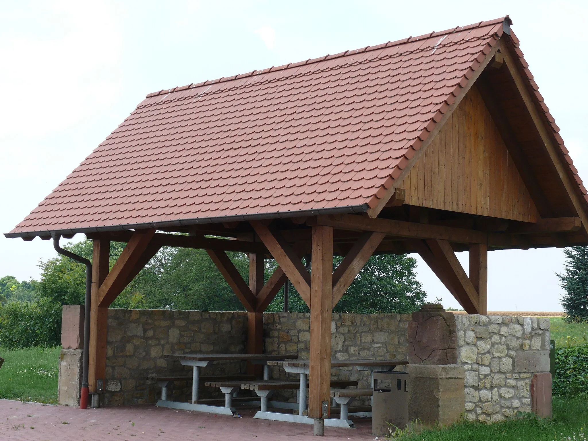 Photo showing: Überdachter Picknickplatz am nordöstlichen Ortseingang von Essenheim, in die Stirnseiten der Ummauerung wurden alte Grabsteine mit eingearbeitet.