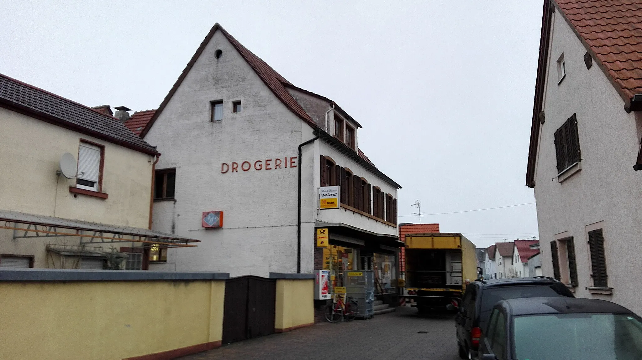 Photo showing: Lingenfeld, Stettenbergstraße mit dem Geschäft Photo & Kosmetik Weiland, das auch eine Postagentur beinhaltet