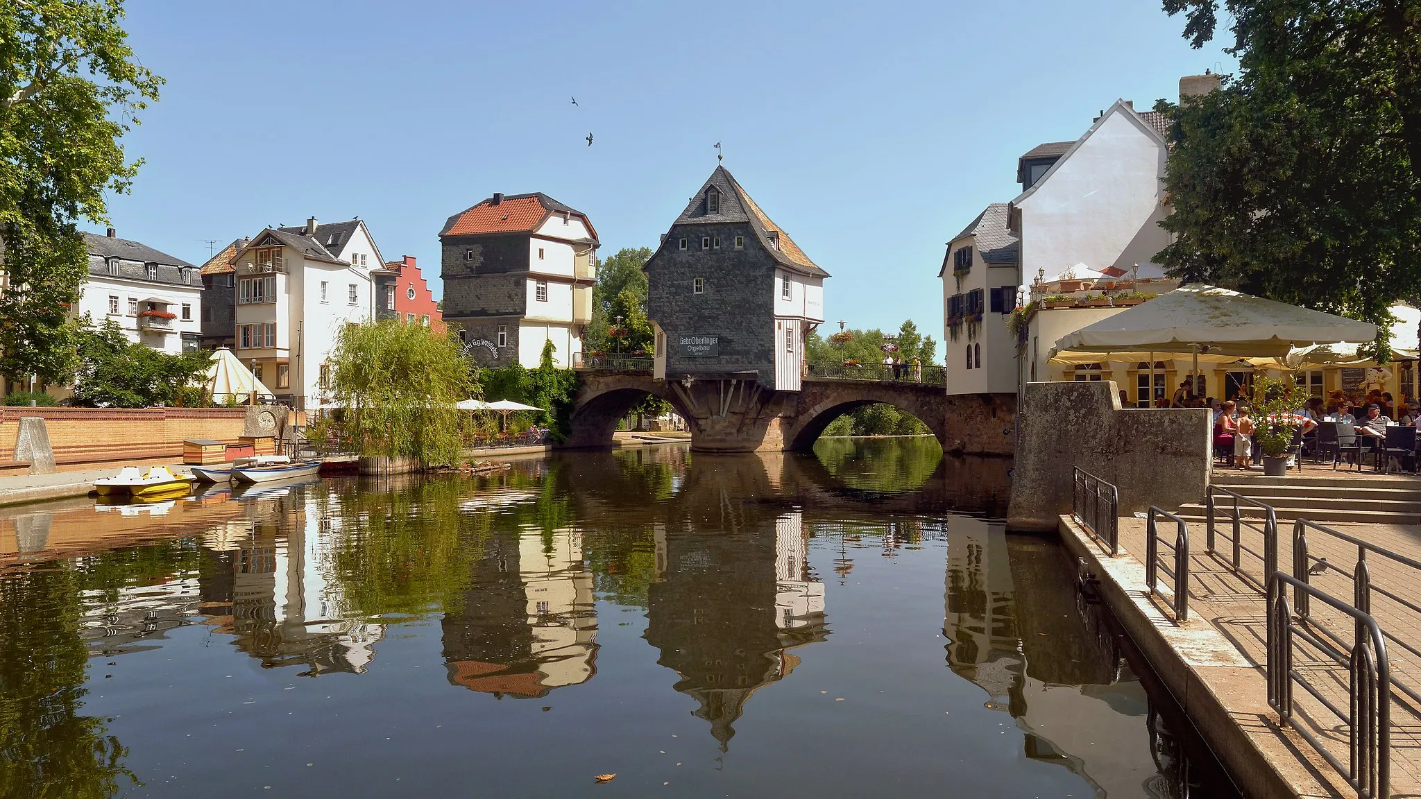 Photo showing: Die Alte Nahebrücke ist eine Brücke in Bad Kreuznach und gehört neben der Krämerbrücke in Erfurt und der Neckarbrücke in Esslingen zu den noch bestehenden Brücken, die mit Häusern bebaut ist. Die Steinbrücke hat eine Länge von 135 Meter und führt über die Nahe und dem Mühlenteich, einen Nebenarm der Nahe. Erbaut wurde die Brücke 1332 und diente als Ersatz für eine Holzbrücke.