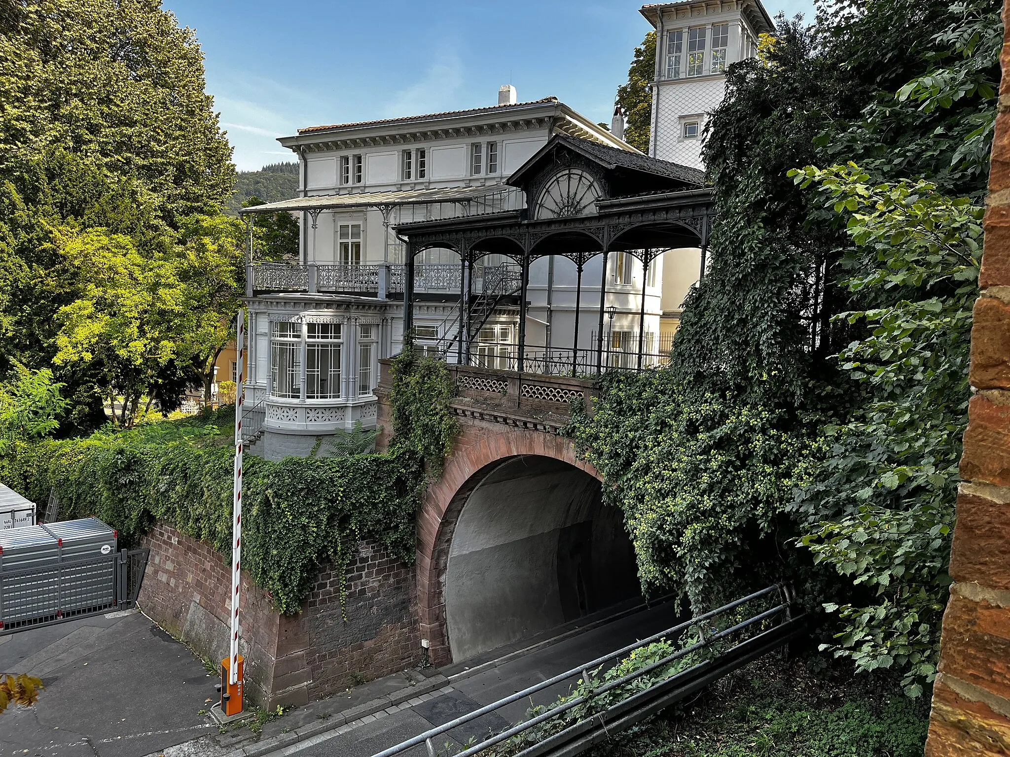 Photo showing: Gaisbergtunnel (west portal, built in 1859/1862) in Heidelberg at the Adenauerplatz. The Odenwaldbahn ran here until 1955, and since 1962 there has been a road tunnel to the Friedrich-Ebert facility. The immediately adjacent listed villa from the 19th century rests on the late medieval fortifications of the Heidelberg suburb.