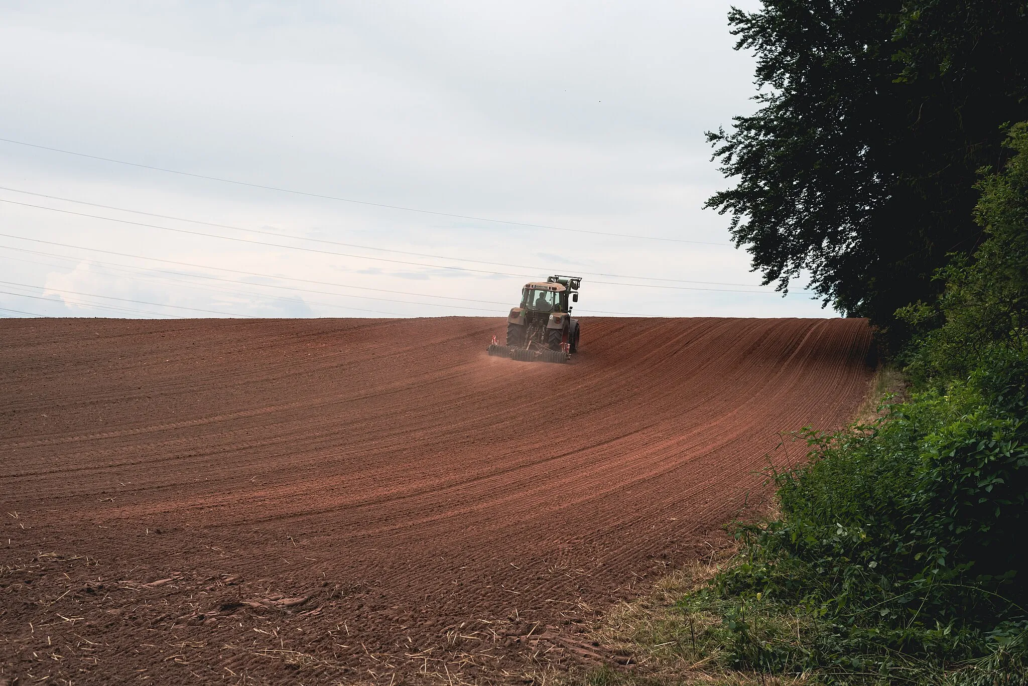 Photo showing: Blick über ein Feld im Landschaftschutzgebiet Gackelsberg und Hirschberg suedllich von Limbach. Auf dem Feld befindet sich ein Traktor.