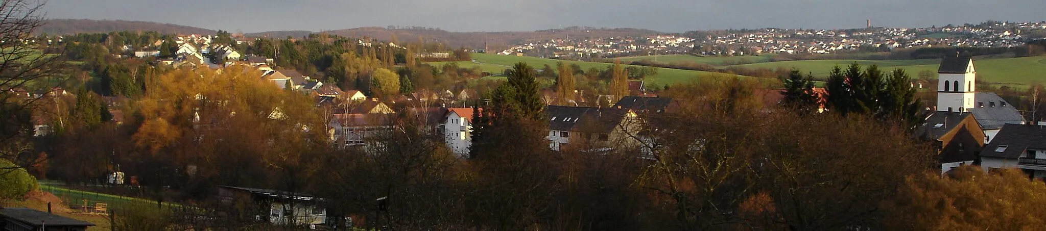 Photo showing: Blick vom Lohberg nach Südosten über die Ortsmitte von Walpershofen. Rechts am Bildrand: die ev. Kirche in der Herchenbacher Straße. Links oben die Kurzenbergstraße, im Hintergrund rechts oben: Riegelsberg