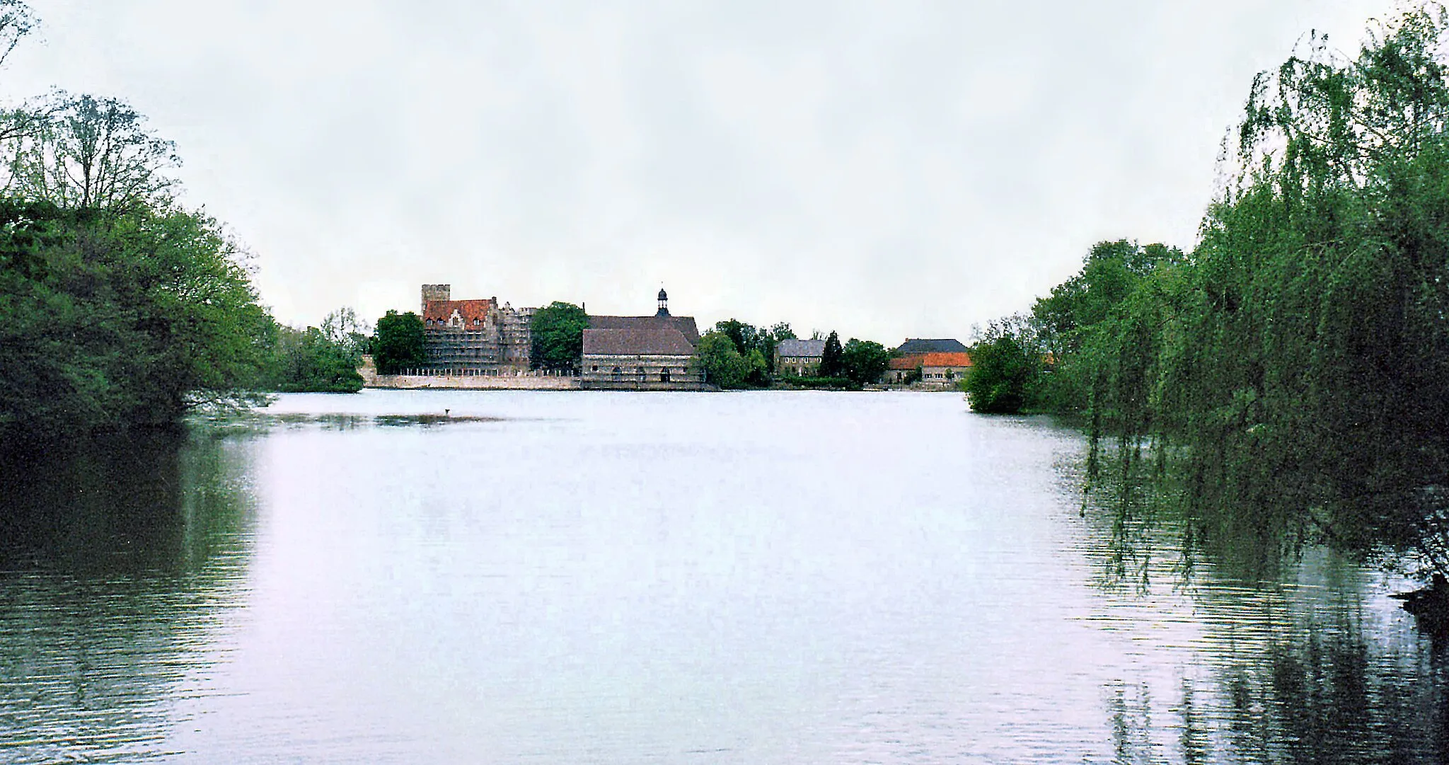 Photo showing: 02.05.2003   39345  Flechtingen, Lindenplatz: Wasserburg/Schloß (GMP: 52.331118,11.238324). Die Wasserburg Flechtingen war der ursprüngliche Stammsitz der Adelsfamilie Schenck von Flechtingen. Die ältesten Gebäudeteile entstanden um 1300, zu ihnen gehören die Ringmauer, der Palas und der Bergfried. Erste große Veränderungen wurden 1483 mit der Verlagerung der Burg nach Westen vorgenommen. Ende des 15. Jahrhunderts wurden spätgotische Bauelemente hinzugefügt, 100 Jahre später erhielt die Anlage Veränderungen im Renaissance-Stil. Um 1600 wurde die ehemalige Zugbrücke durch eine Dammzufahrt ersetzt. Bei den letzten Umbauten zwischen 1840 und 1890 erhielt das Wasserschloß sein historistisch-neugotisches Aussehen. Nach der Enteignung des Schlosses diente es 1945 zunächst als Flüchtlingsunterkunft. Danach wurde es als Genesungsheim genutzt, ehe es 1958 von den Grenztruppen der Volksarmee übernommen wurde. Von 1964 bis 1993 war das Schloß ein Altersheim.                                                                                                                                                                                                                                                [F20030502A005.jpg]20030502570NR.JPG(c)Blobelt