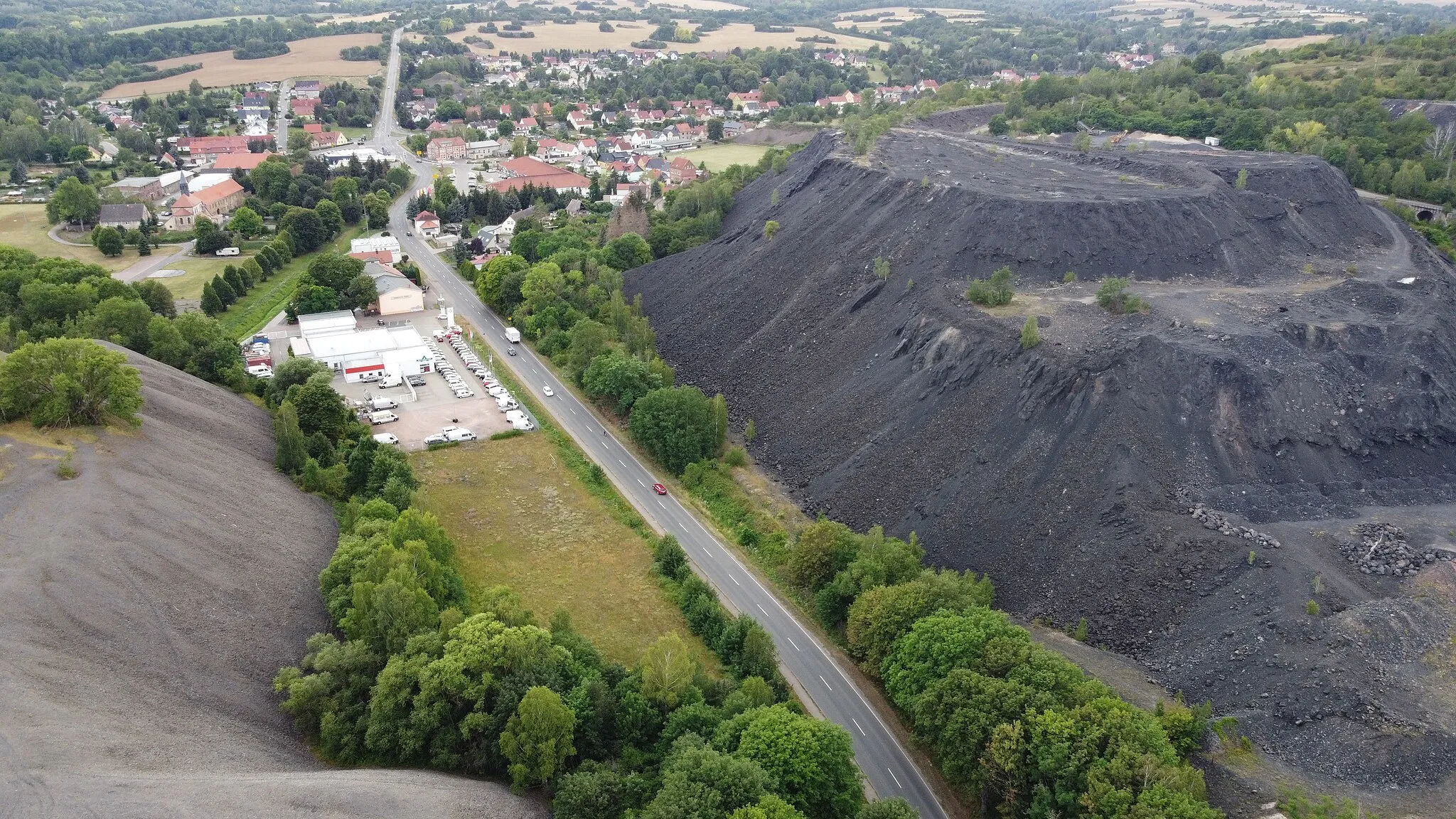 Photo showing: Stockpiles from kupferschiefer smelting in Wimmelburg / Saxony-Anhalt, slag stockpile on the right hand side, zechstein stockpile on the left hand side