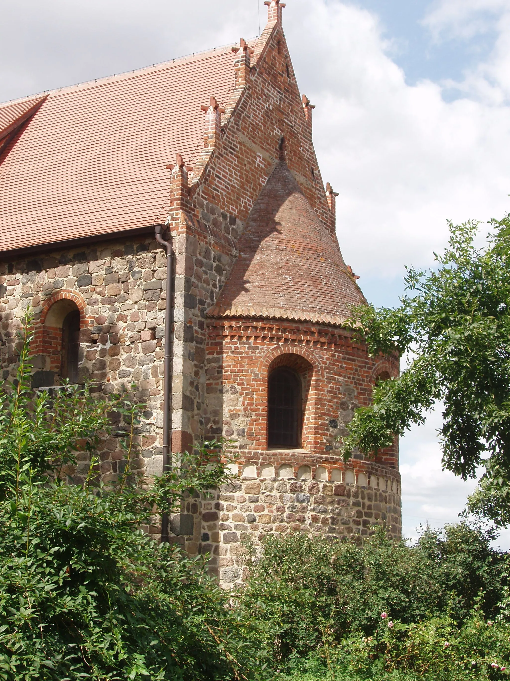 Photo showing: Der mit Türmchen verzierte Giebel des Kirchenschiffs mit der kleinen, wenig ausladenden Apsis der aus sorgfältig zu Quadern behauenen Feldsteinen errichteten Klosterkirche in Krevese.