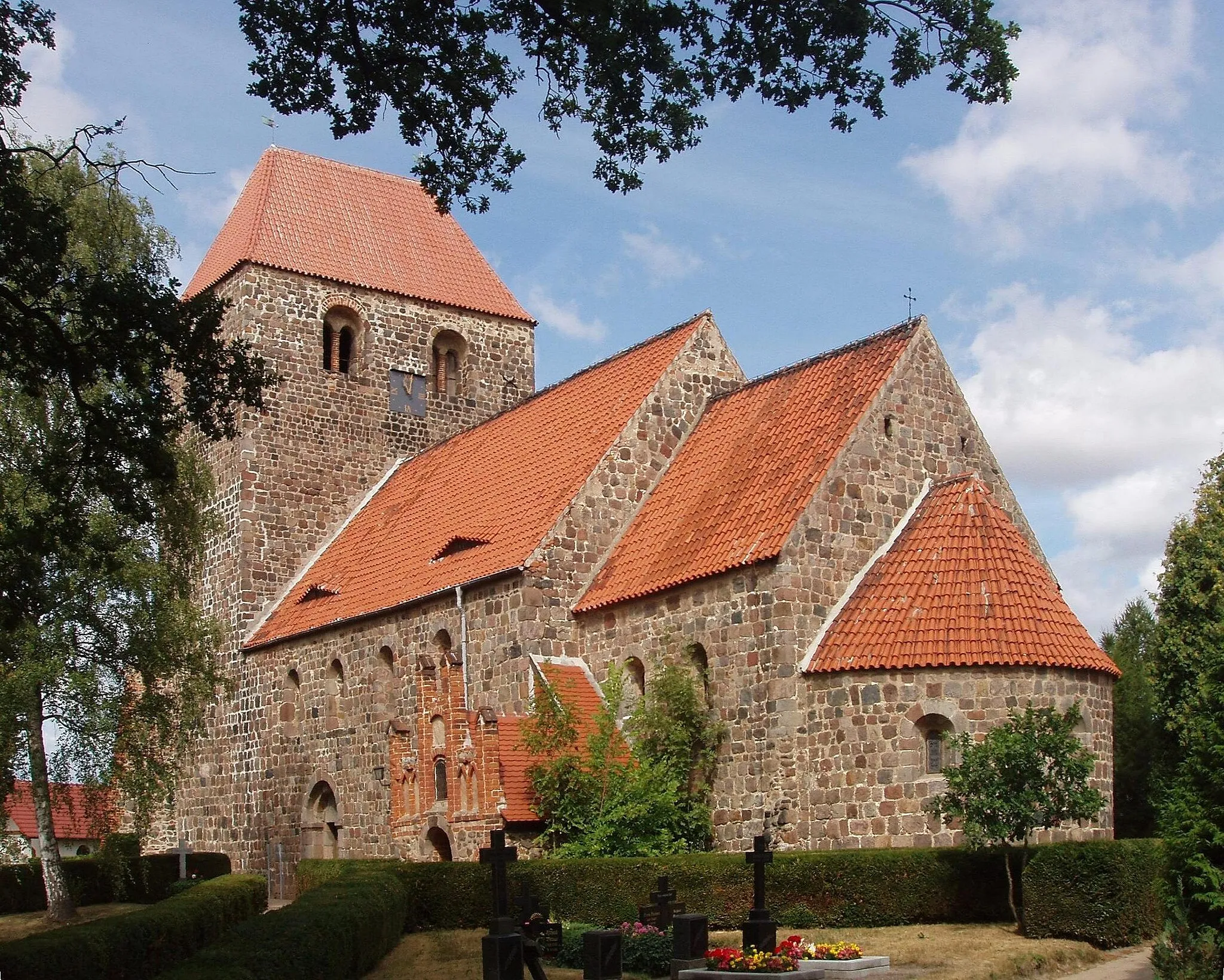 Photo showing: Die spätromanische Kirche St. Leonhard (Ersterwähnung 1201) gehört der Architektur nach zu dem weitverbreiteten, sog. vollständigen Dorfkirchentyp, der durch die Abfolge (von West nach Ost): breiter Turm mit Satteldach, gleichbreites Schiff, eingezogener rechteckiger oder quadratischer Chor und Apsis gekennzeichnet ist. Der Turm hat meterdicke Wände; er diente zugleich als Verteidigungsanlage und Fluchtstätte. In der langen Zeit des Bestehens der Kirche gab es auch bauliche Veränderungen, so trägt der Turm jetzt ein Walmdach.