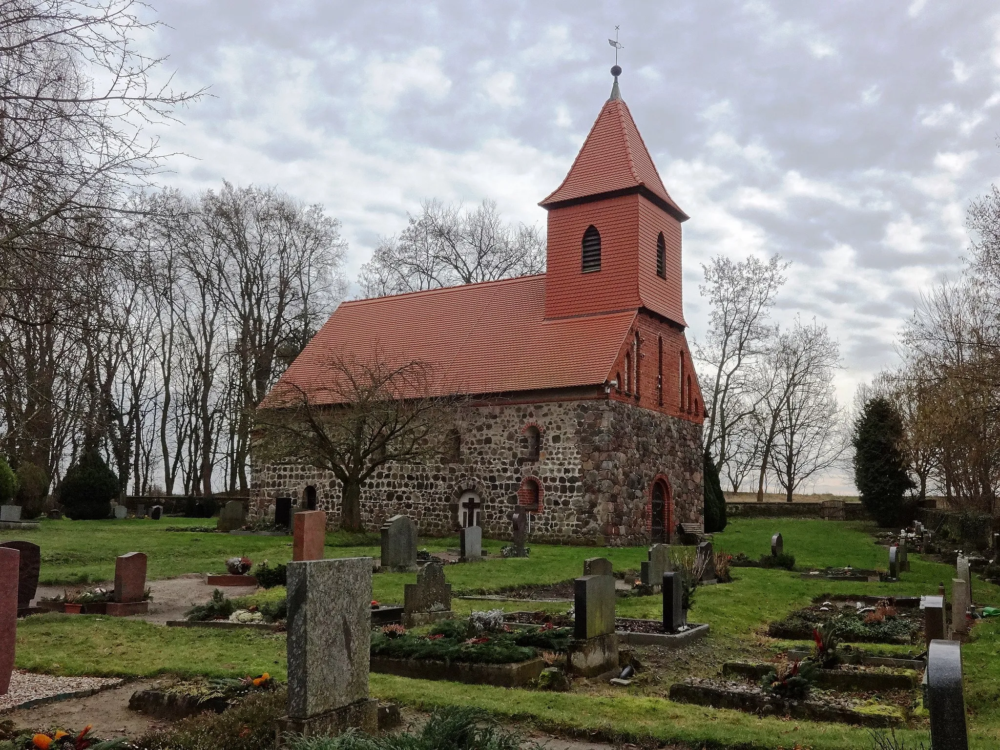 Photo showing: Die Dorfkirche Rädigke ist eine Feldsteinkirche, die vermutlich Ende des 12. Jahrhunderts oder Anfang des 13. Jahrhunderts entstand. 1858 erfolgte eine Renovierung des Innenraums; 1903 wurden die Fenster am Kirchenschiff vergrößert. Im Innern befinden sich ein Altarretabel aus dem Jahr 1690 sowie eine Kanzel aus dem Jahr 1703.