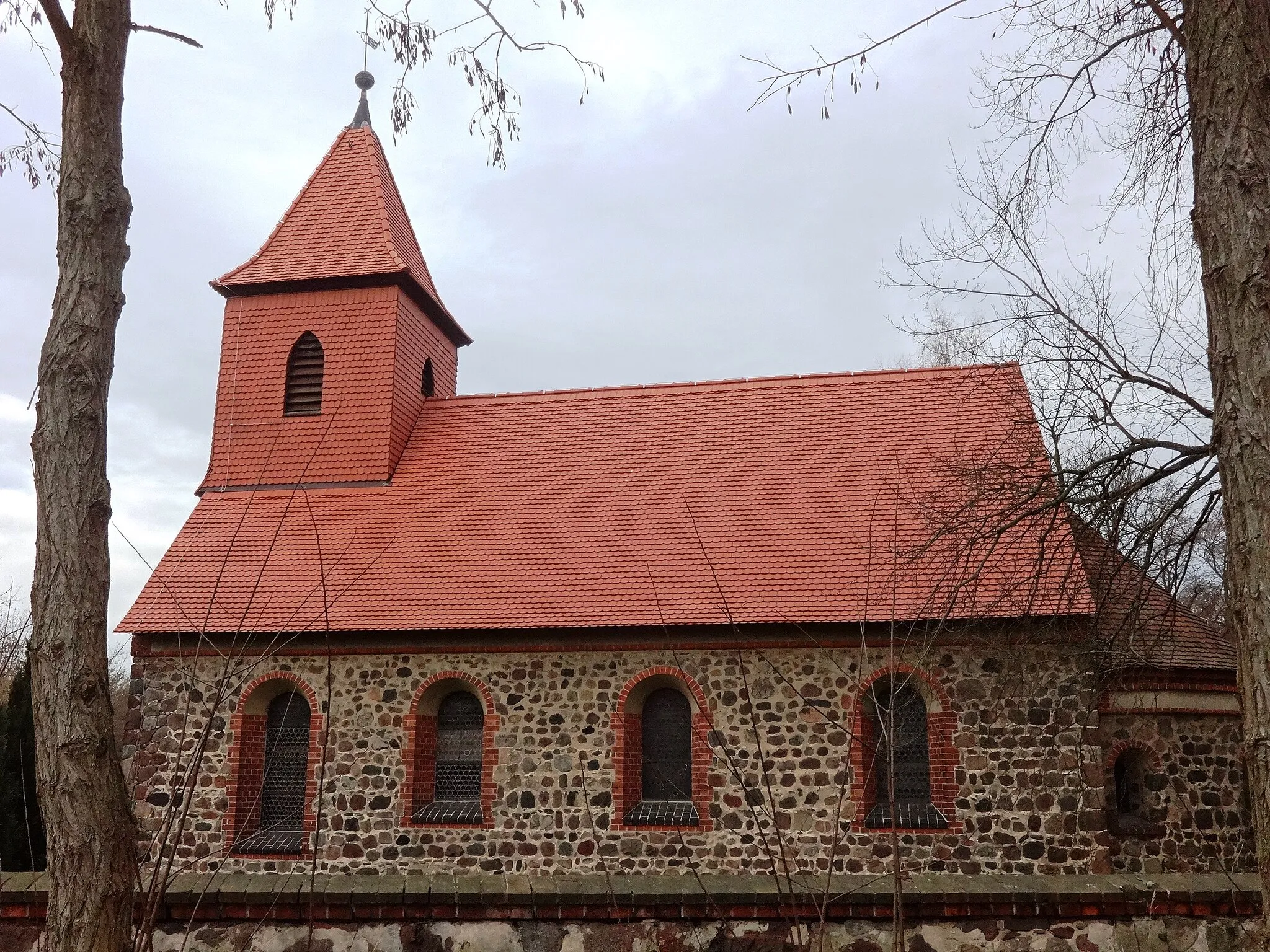 Photo showing: Die Dorfkirche Rädigke ist eine Feldsteinkirche, die vermutlich Ende des 12. Jahrhunderts oder Anfang des 13. Jahrhunderts entstand. 1858 erfolgte eine Renovierung des Innenraums; 1903 wurden die Fenster am Kirchenschiff vergrößert. Im Innern befinden sich ein Altarretabel aus dem Jahr 1690 sowie eine Kanzel aus dem Jahr 1703.