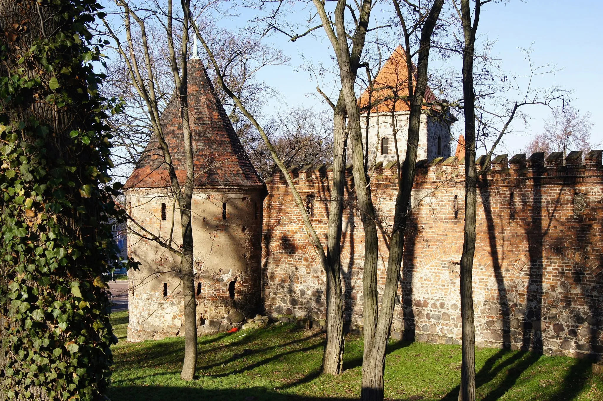 Photo showing: City wall at Breitestraßetor ("Broadstreetgate") in Zerbst/Anhalt, Saxony-Anhalt, Germany. View from castle garden to fortress tower "Kuchels Warte" ("Kuchels Observation Point") and the Dornburg Gate