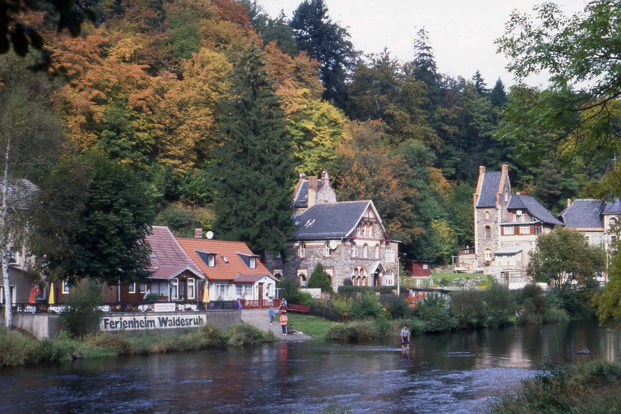 Photo showing: Where many holiday hotels and guest houses were located, included the Ferienheim Waldesruh. A man appears to be walking across the river.