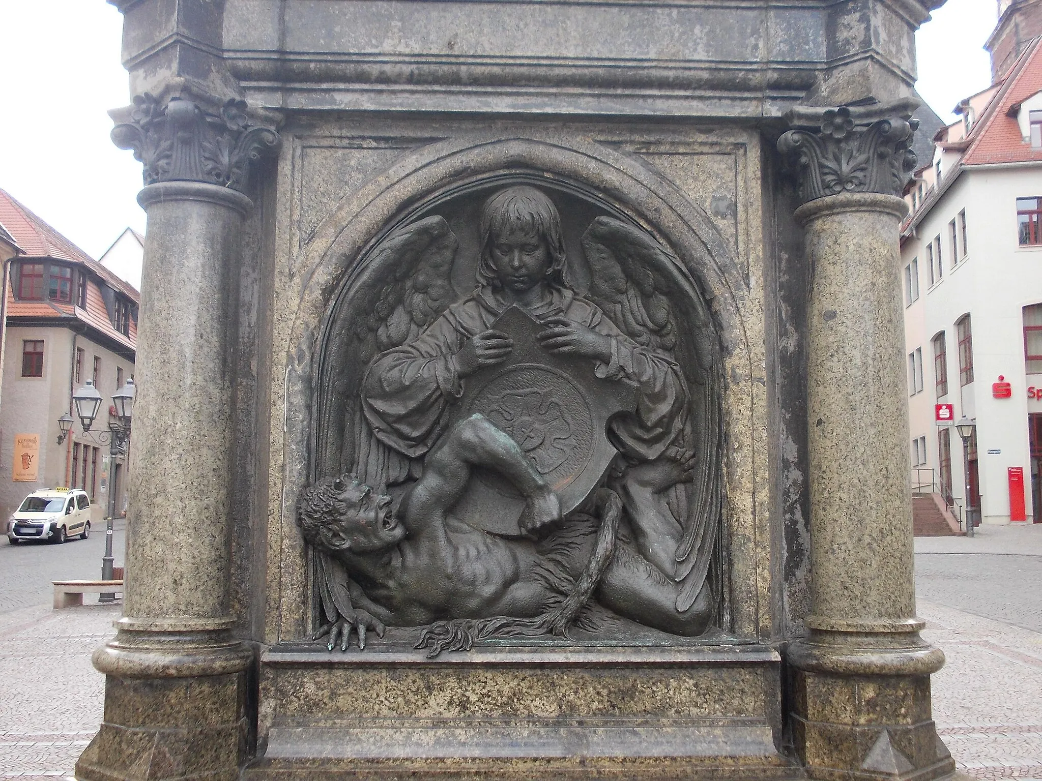 Photo showing: A relief of the Martin Luther Memorial in Eisleben (Mansfeld-Südharz district, Saxony-Anhalt): the devil defeated by the angel