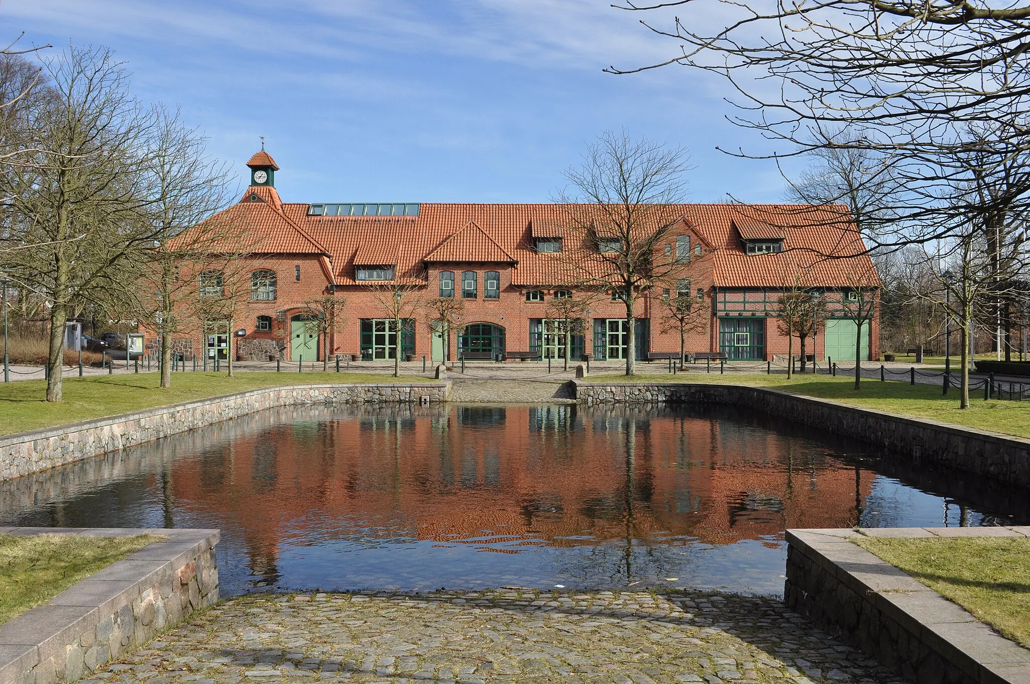 Photo showing: Dorfgemeinschaftshaus Pferdestall in Hoisbüttel (Ammersbek). Im Vordergrund die zugehörige Pferdeschwemme.