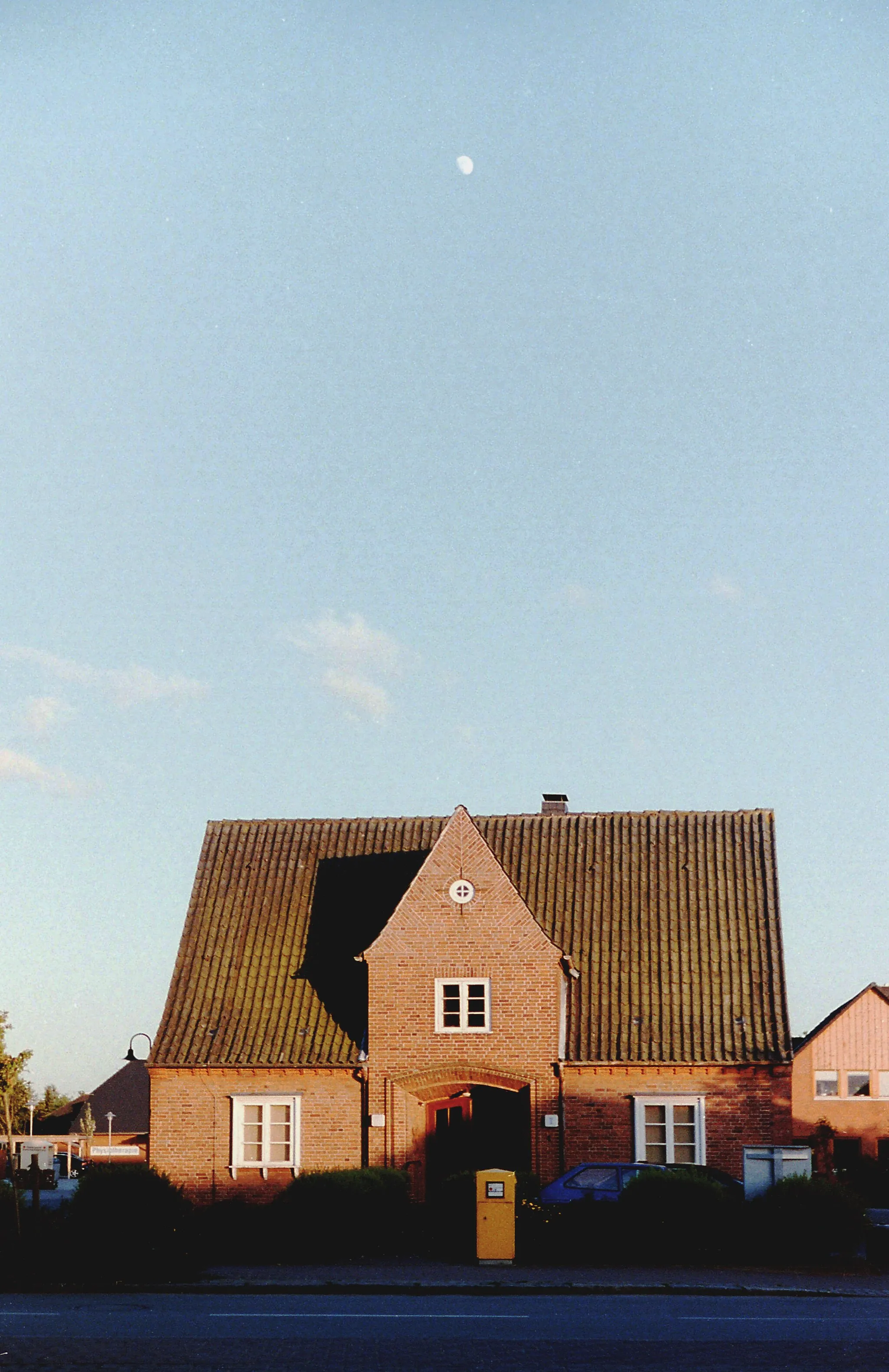 Photo showing: Ehemaliges Gebäude der Raiffeisenbank im Ortszentrum von Bredenbek, Schleswig-Holstein. The white dot above the top of the former building of the Raiffeisenbank is the moon.