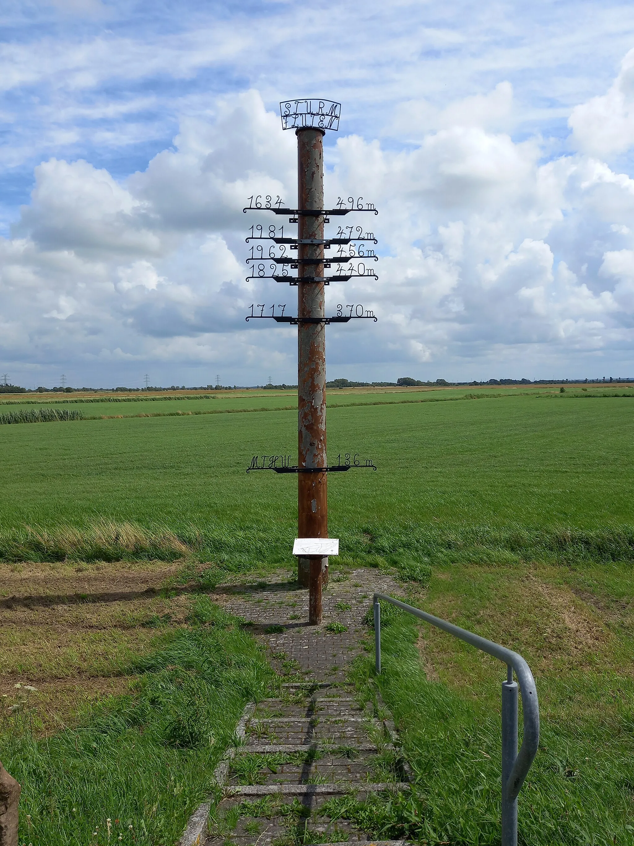 Photo showing: An der Grenze zwischen Stedesand und Risum-Lindholm befindet sich an der Abzweigung zum Trollebüller Weg ein Denkmal zur Erinnerung an historische Sturmfluten.