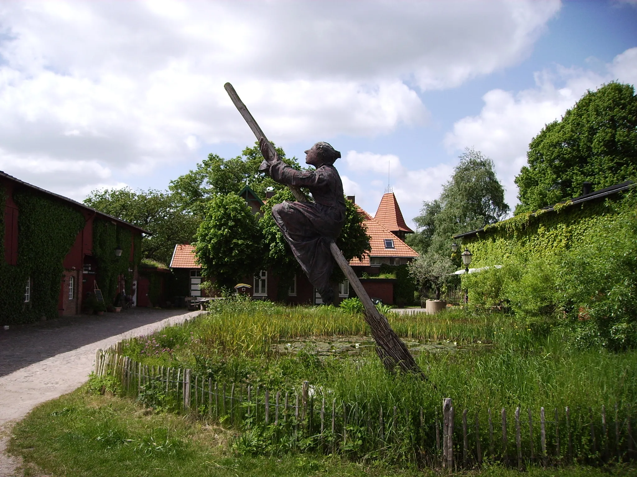 Photo showing: Ansicht des Innenhofs des Kräuterparks in Stolpe, mit Holzplastik in Form einer auf einem Besen reitenden Hexe