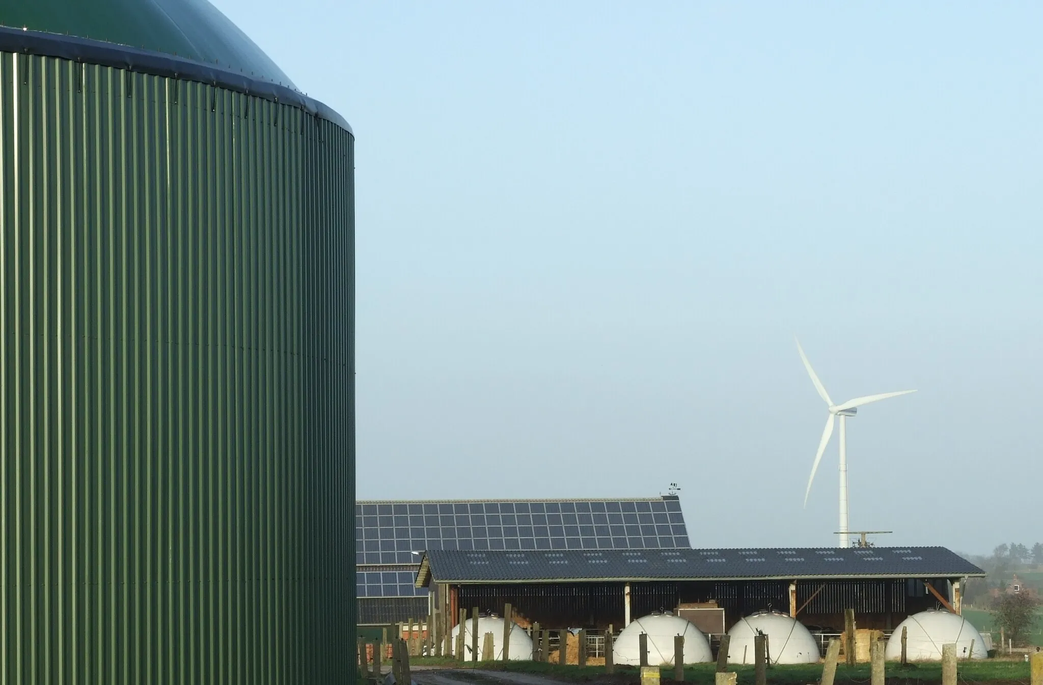 Photo showing: Renewable Energies: Biogas (fermenter), wind power and photovoltaics on a farm in Horstedt (Schleswig-Holstein/ Germany)