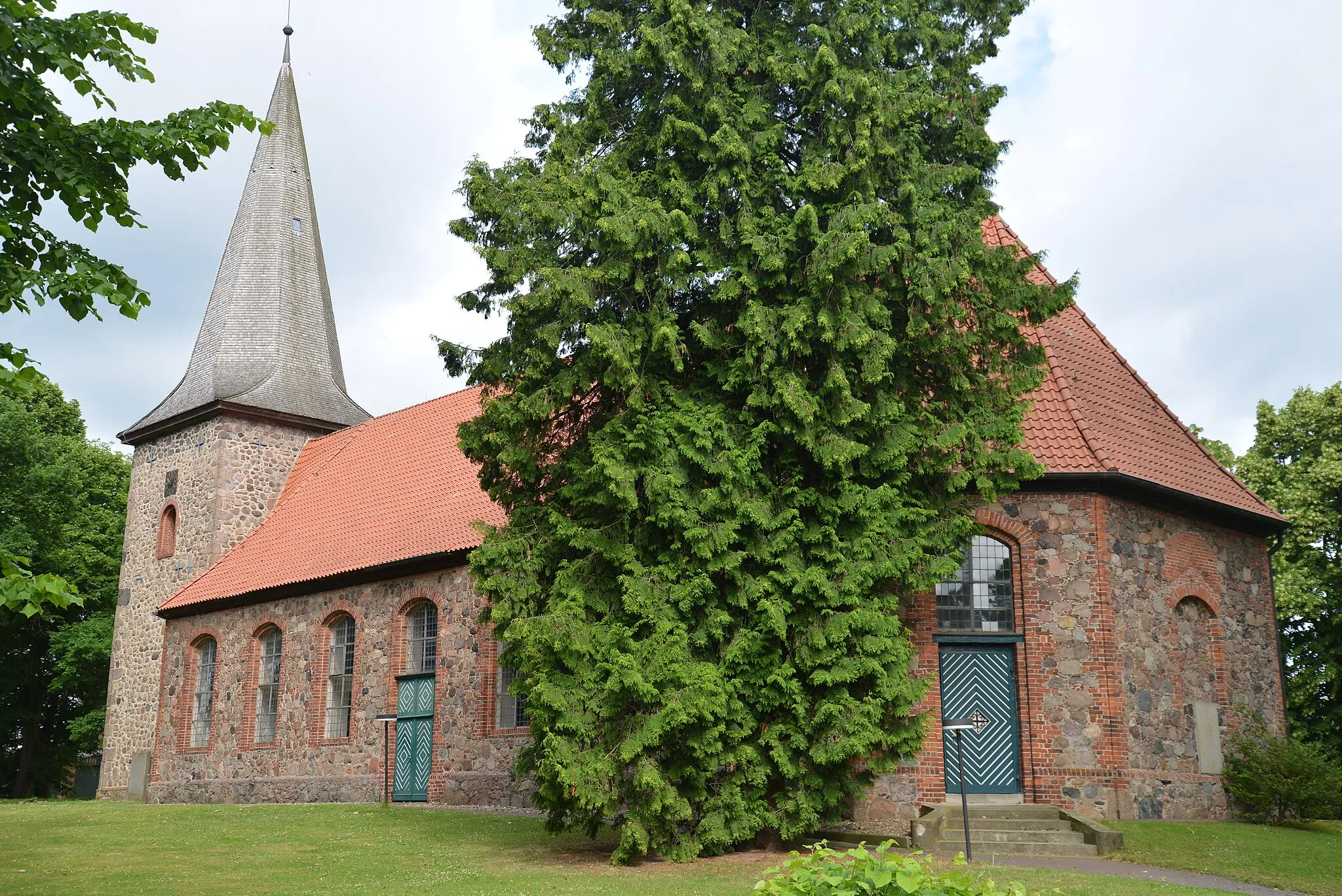 Photo showing: Die Kirche St. Johannis in Siebeneichen wurde 1753 aus nordischen Geschieben gebaut, der Turm wurde 1909 erneuert. Auf diesem Bild wird die Bauart deutlich. Man sieht die unterschiedliche Bauweise von Kirchturm (aus gesetzten Findlingen mit Ecksteinen aus Granit erneuert) und Kirchenschiff (aus kleineren Findlingen und Backsteinbruch, mit Ecken aus Backstein), ebenso wie eine spätere Erhöhung des Kirchturms.