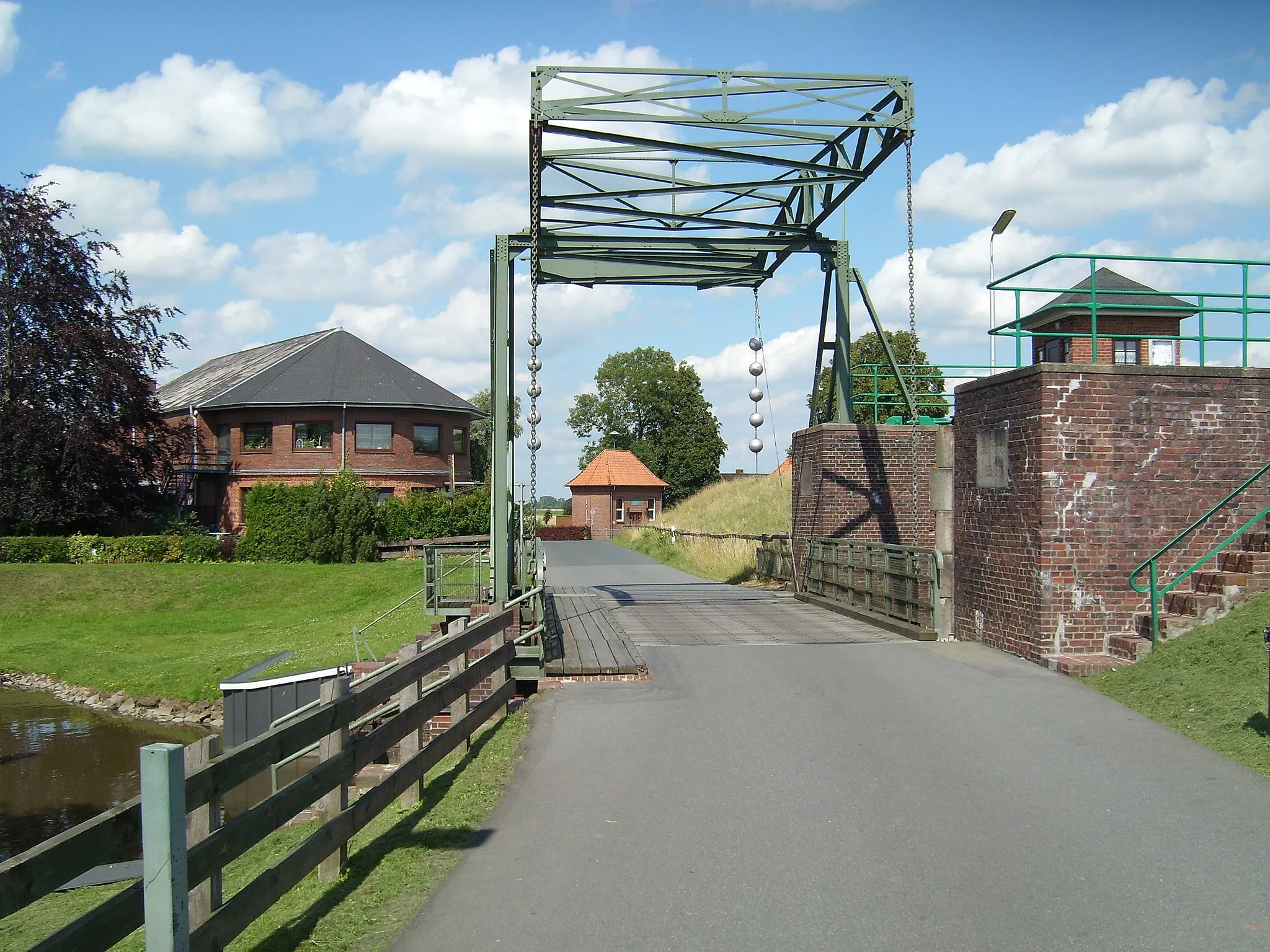 Photo showing: Straßenbrücke bei der Schleuse Kasenort. Im Hintergrund (Bildmitte) zu sehen ist das 1955/56 erbaute Schöpfwerk, über das die Große Feldwettern in die Stör entwässert.