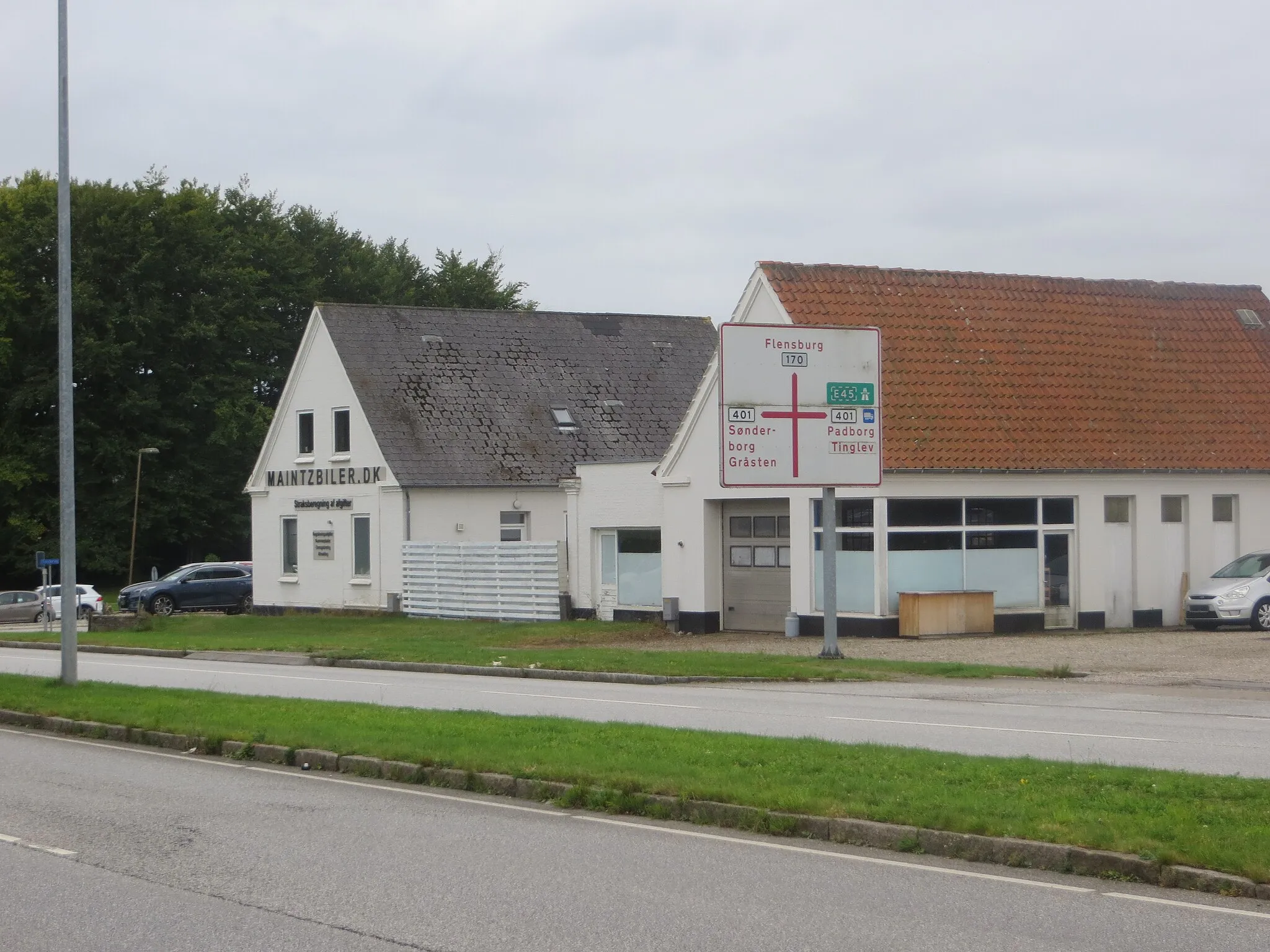 Photo showing: Krusau (Kruså), Schleswiger Ganzmeilenstein „1 Miil fra Flnsbg“, Blick zurück zur Kreuzung
am Ortsausgang in Richtung Aabenraa (Apenrade), Aabenraavej (Apenrader Straße), etwa 150 m nördlich der zentralen Kreuzung im Ort,
östliche Straßenseite im Straßengraben, zusätzlich hat der Stein einen vertieften Schriftfeldspiegel, der Einsatz fehlt