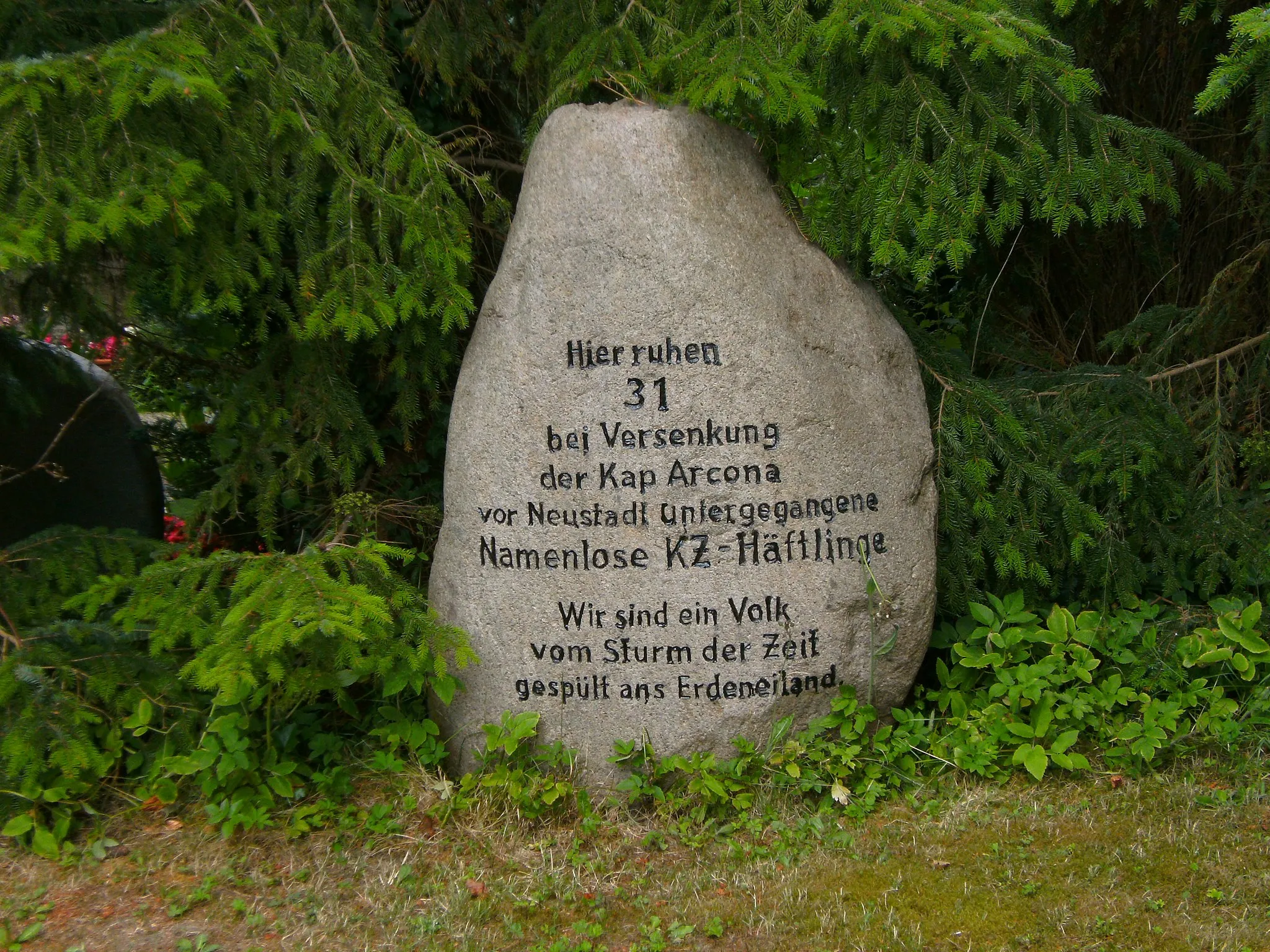 Photo showing: There is a mass grave in Grube (Holstein) for 31 concentration camp inmates, who died by the Cap Arcona catastrophy. The graveyard is at the street B 501 at the outskirts of the village. A memorial stone at the right side of the cemetery chapel marks the mass grave.